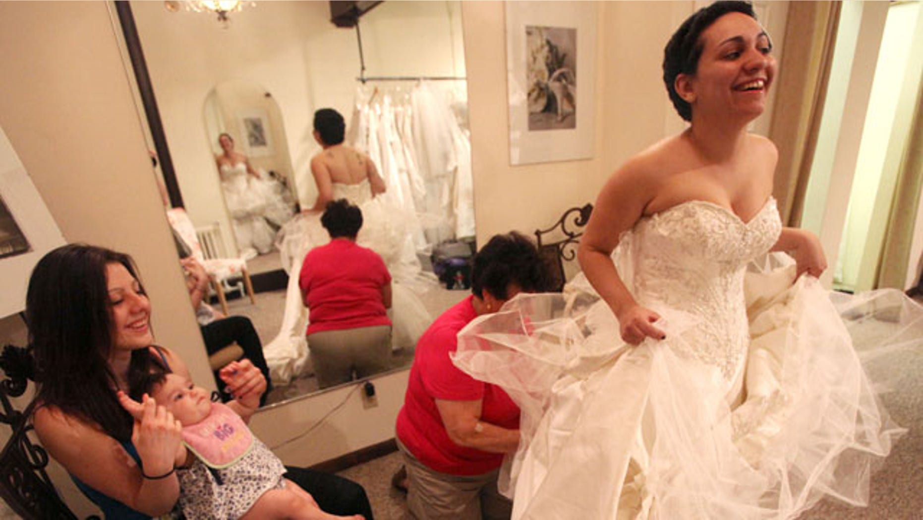 April 8, 2010: Stopping bythe Newburgh dress shop, Bella Coutre, the shop that donated her wedding gown, Jessica Vega is fitted for her wedding gown. Her friend, Kourtney Currier minds Ava at left, while Lorenza Martelli works on the dress.