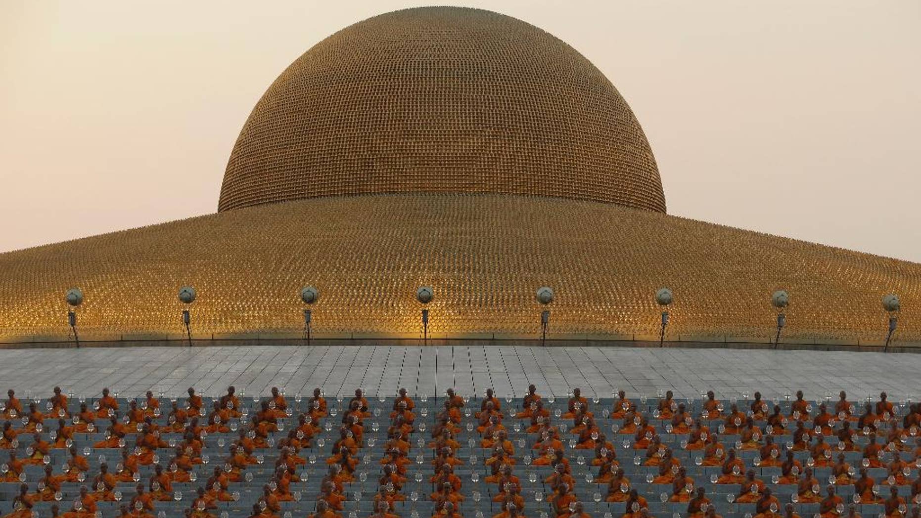 In this Feb. 22, 2016 photo, Thai Buddhist monks pray and gather at Wat Dhammakaya temple to participate in Makha Bucha Day ceremonies in Pathum Thani, Thailand, The Office of the Attorney-General announced Wednesday, Nov. 23, 2016 its decision to bring to court Phra Dhammachayo, the abbot of Wat Dhammakaya, a monastery north of Bangkok. He and four other persons will be charged with conspiracy to launder money, money laundering and receiving stolen property. (AP Photo/Sakchai Lalit)