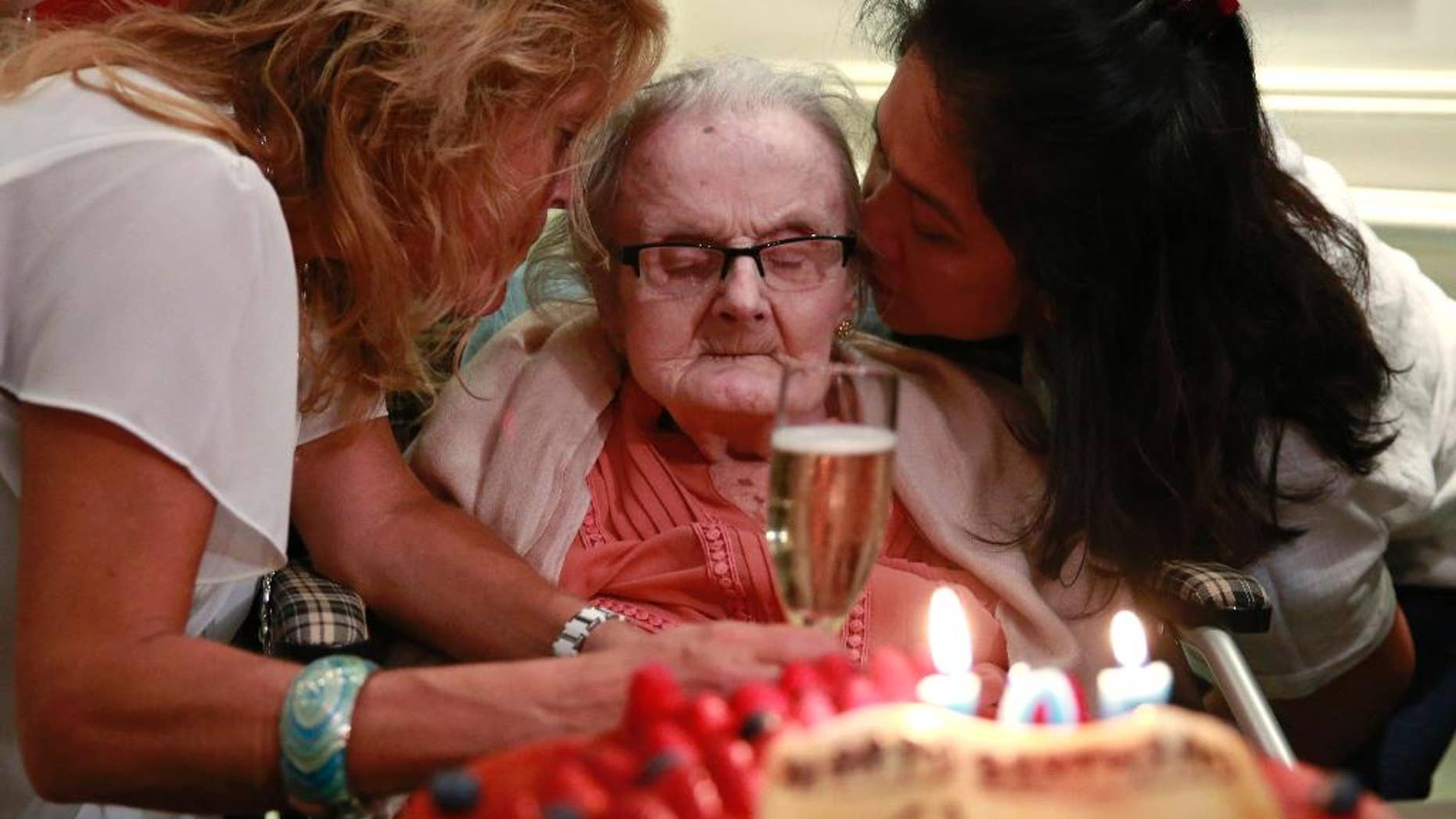 FILE - This is a Monday, Oct. 10, 2016 file photo of Clare Hollingworth, center, a British former longtime foreign correspondent, is surrounded by friends and admirers at her birthday party at Hong Kong's Foreign Correspondents' Club. British war correspondent Clare Hollingworth, who broke the news of the Nazi invasion of Poland that started World War II, has died in Hong Kong Tuesday Jan. 10, 2017, at the age of 105. She spent her life on the front lines of the world's major conflicts, reporting from the Middle East, North Africa and Vietnam, for British newspapers, then lived her final decades in Hong Kong after being stationed in China in the 1970s. (AP Photo/Kin Cheung, File)