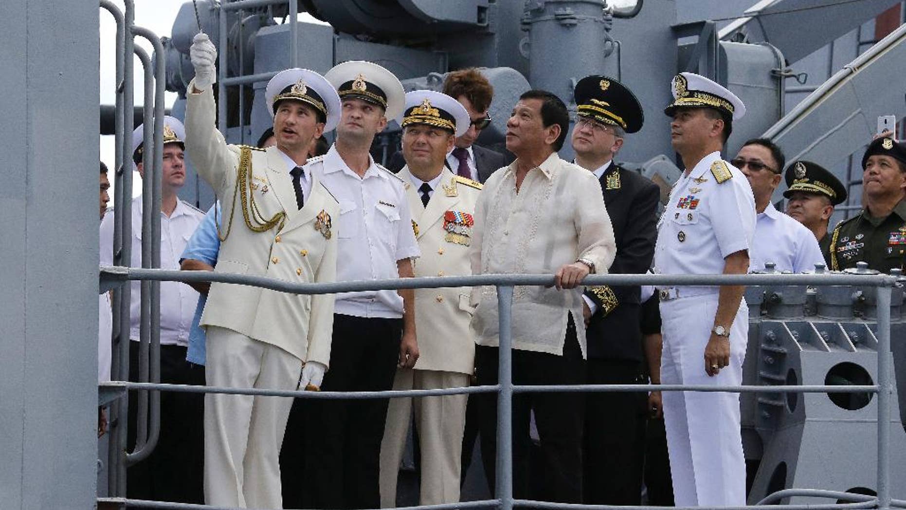 PhilippineS President Rodrigo Duterte, center, watches as Russian navy officers show the weapons on board the Russian anti-submarine Navy vessel Admiral Tributs in Manila.