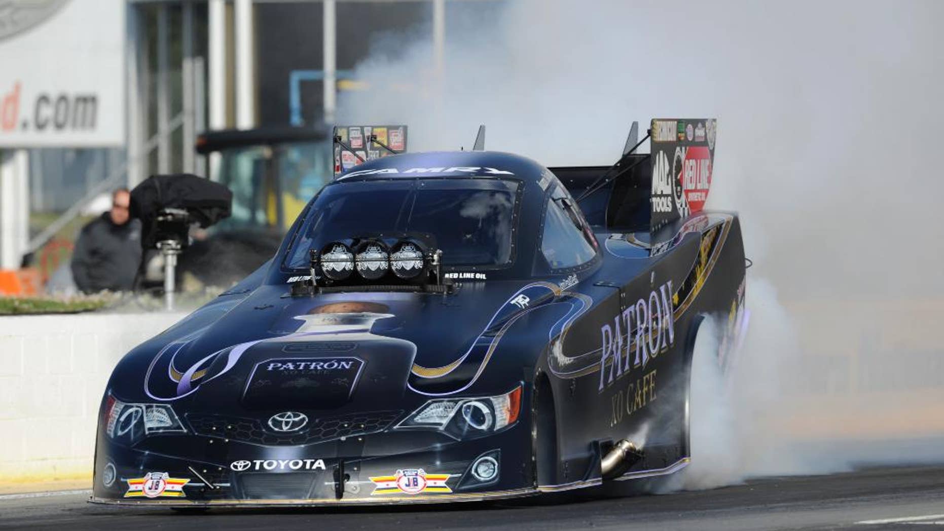 In this photo provided by the NHRA, Alexis DeJoria does a burnout during Funny Car qualifying for the NHRA Southern Nationals drag races at Atlanta Dragway on Friday, May 16, 2014, in Commerce, Ga. DeJoria took the top spot on the first day of qualifying. (AP Photo/NHRA, Marc Gewertz)