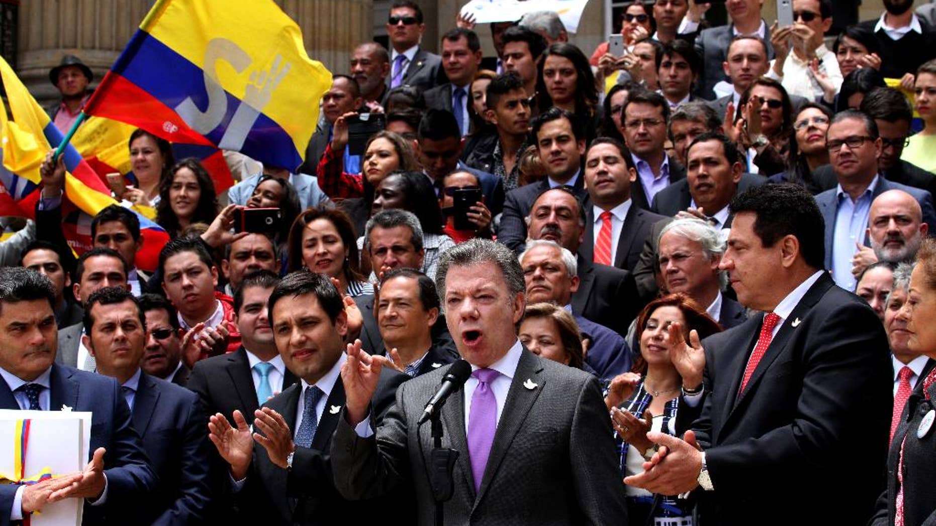 Colombia's President Juan Manuel Santos, front, second from right, speaks after delivering to Congress the peace deal with rebels of the Revolutionary Armed Forces of Colombia, FARC, in Bogota, Colombia, Thursday, Aug. 25, 2016. Santos is moving fast to hold a national referendum on a peace deal meant to end a half-century conflict with leftist rebels, delivering the final text of the deal on Thursday to Congress and declaring a definitive ceasefire against the guerrillas.(AP Photo/Felipe Caicedo)
