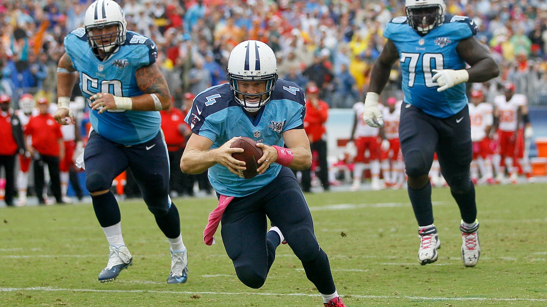 Tennessee Titans quarterback Ryan Fitzpatrick (4) dives into the end zone to score a touchdown on a 9-yard run against the Kansas City Chiefs in the fourth quarter of an NFL football game on Sunday, Oct. 6, 2013, in Nashville, Tenn. Titans linemen Rob Turner (59) and Chance Warmack (70) follow Fitzpatrick. (AP Photo/Wade Payne)