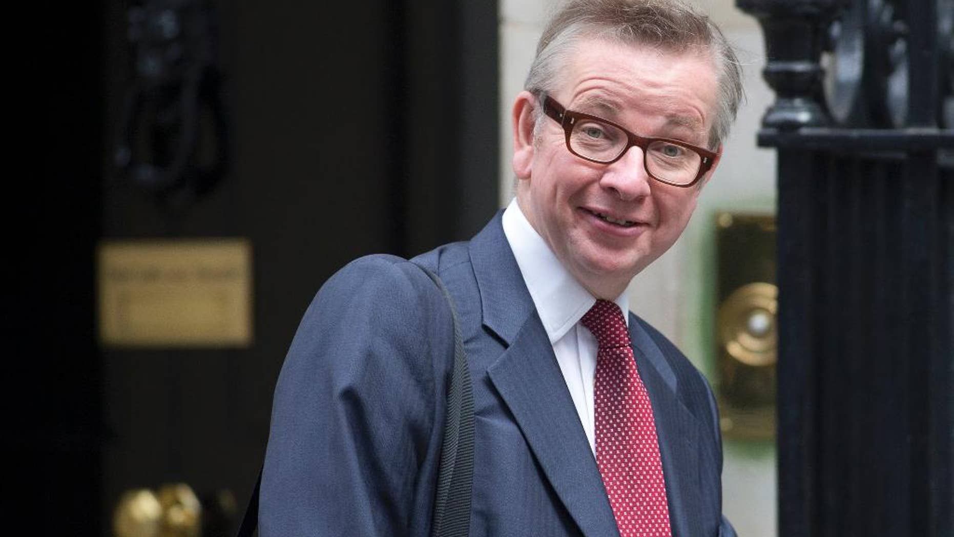 FILE - In this Wednesday, Sept. 11, 2013 file photo, senior cabinet minister Michael Gove looks across to the media as he leaves 10 Downing Street in London. Justice Secretary Michael Gove who wants Britain to leave the European Union accused his opponents Tuesday April 19, 2016 of treating voters like children and trying to scare them into staying put. (AP Photo/Alastair Grant, File)