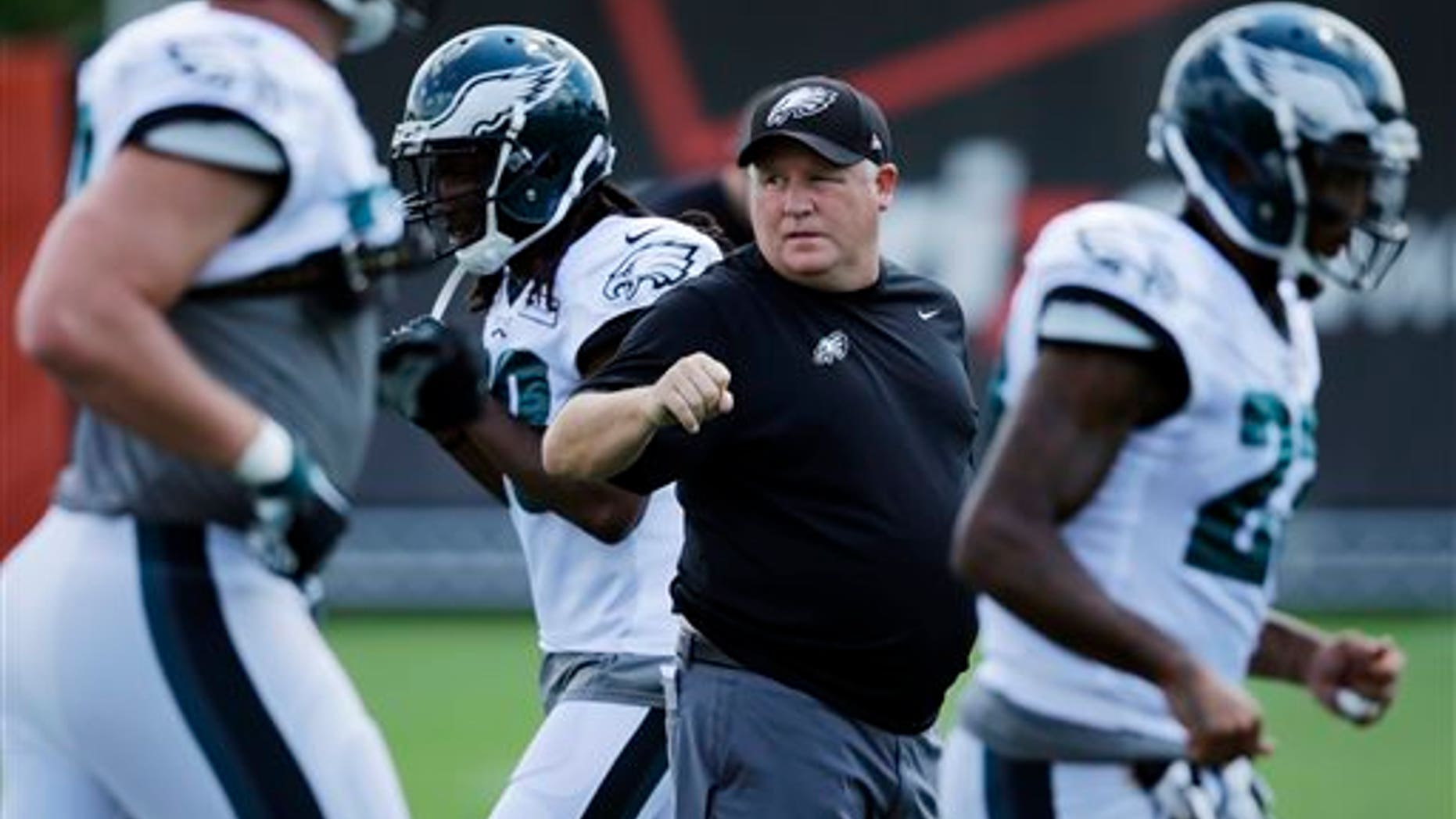 Philadelphia Eagles head coach Chip Kelly watches his team warm up before practice at NFL football training camp, Wednesday, Aug. 12, 2015, in Philadelphia. (AP Photo/Matt Slocum)