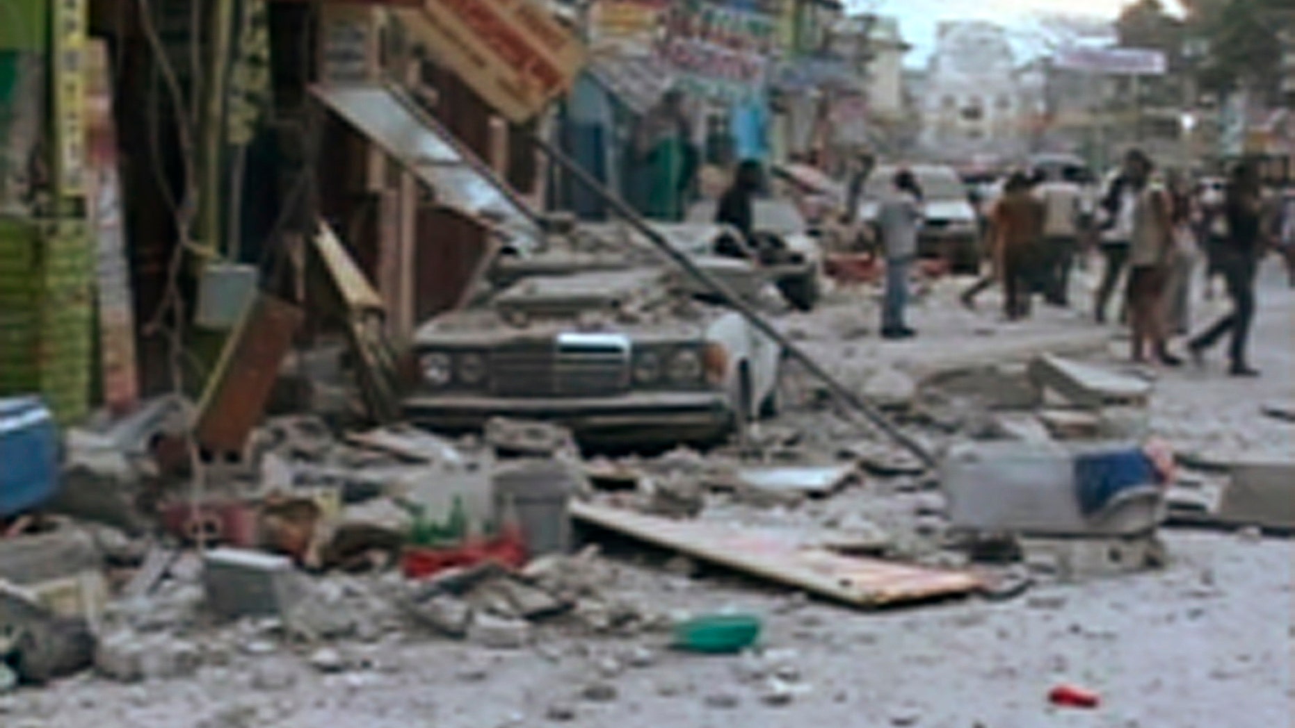 A car damaged after an earthquake struck is seen in Port-au-Prince in this January 12, 2010 video grab. A major earthquake hit impoverished Haiti on Tuesday, toppling buildings in the capital Port-au-Prince, burying residents in rubble and causing many deaths and injuries, witnesses in the city said.