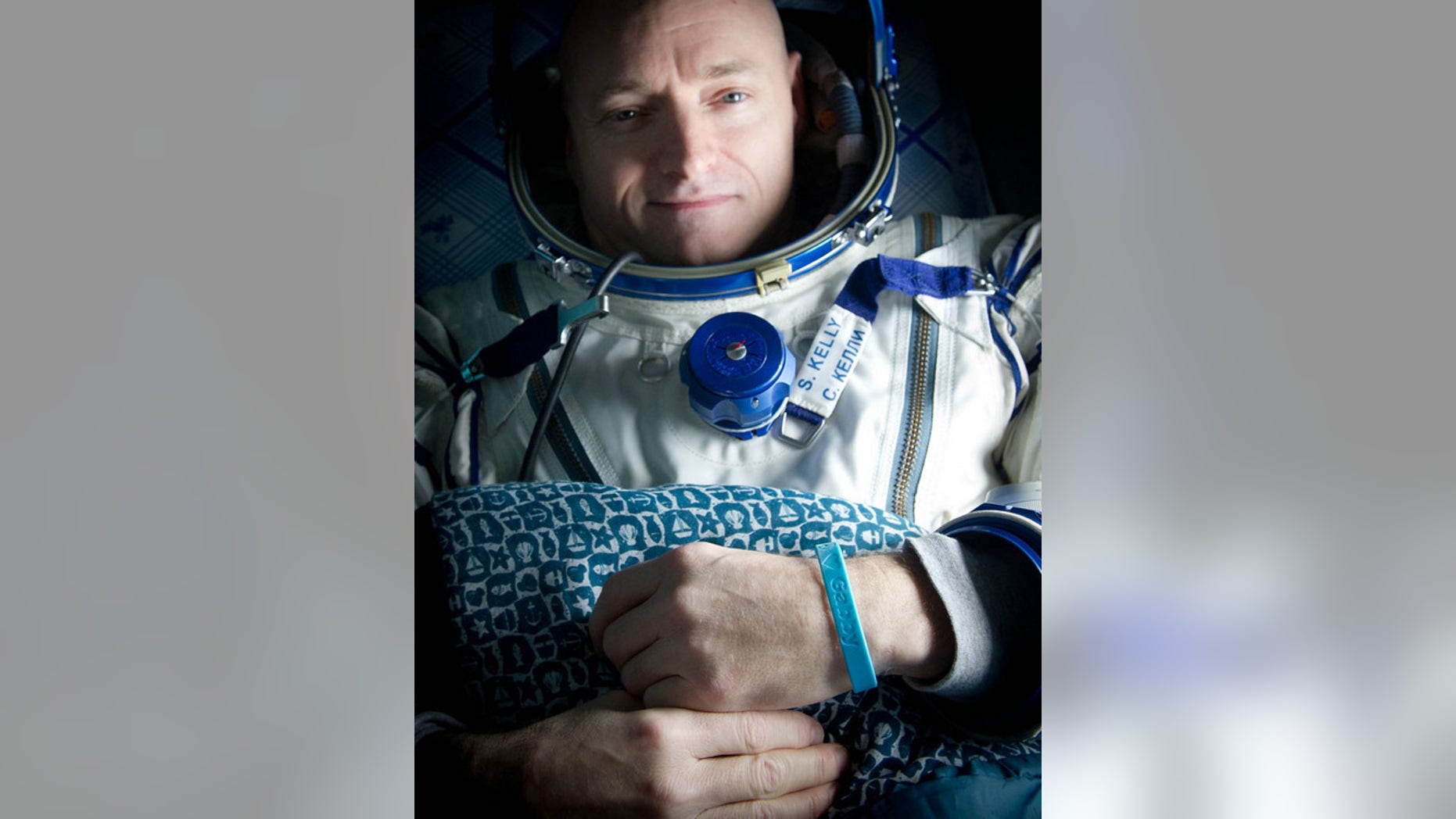 Expedition 26 Commander Scott Kelly wears a blue wrist band that has a peace symbol, a heart and the word "Gabby" to show his love of his sister-in-law U.S. Rep. Gabrielle Giffords as he rests onboard a Russian Search and Rescue helicopter shortly after he and fellow crew members Oleg Skripochka and Alexander Kaleri landed in their Soyuz TMA-01M capsule near the town of Arkalyk, Kazakhstan on Wednesday, March 16, 2011.