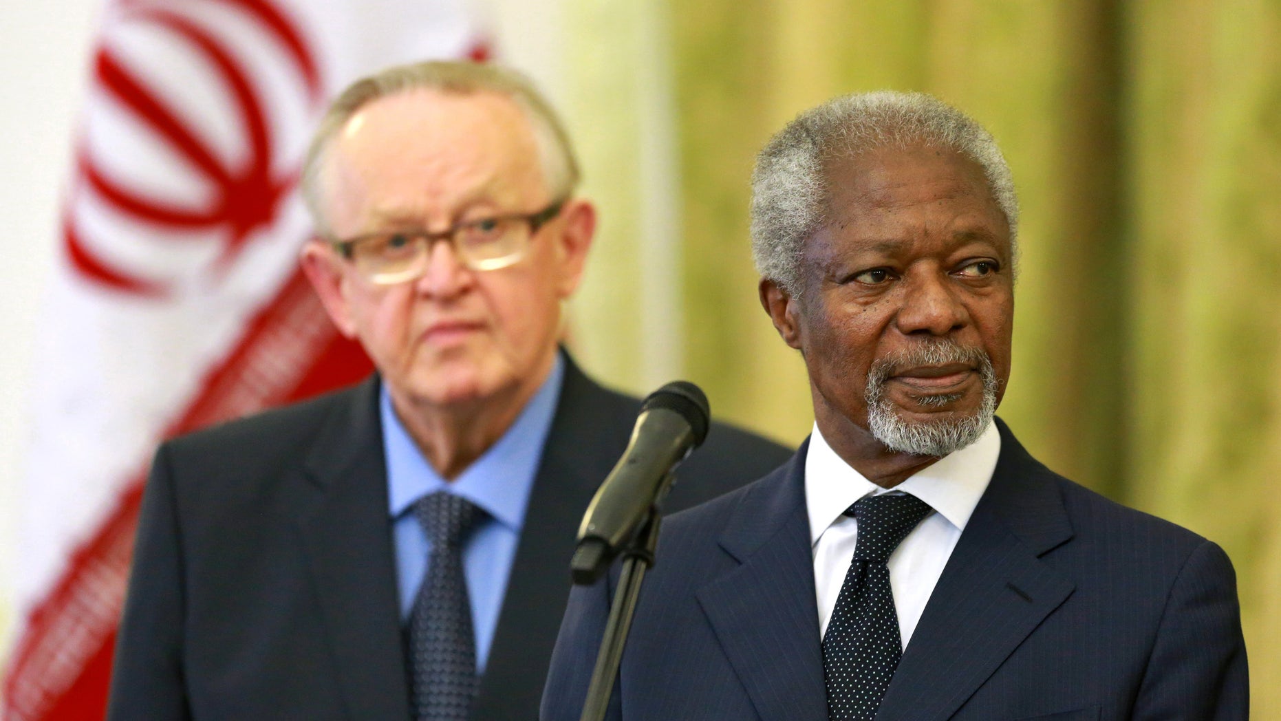 Kofi Annan, former U.N. secretary general, right, reads a statement at the conclusion of his meeting with Iran's Foreign Minister Mohammad Javad Zarif in Tehran, Iran, Monday, Jan. 27, 2014, as Martti Ahtisaari, pormer president of Finland, left, listens. The former head of the United Nations urged Iran Monday to build on a historic deal reached with world powers in November and work toward a final settlement over its contested nuclear program. Annan, who is heading a group of ex-world leaders known as "The Elders," made the comments after a meeting with Iran's Foreign Minister Mohammad Javad Zarif Monday. (AP Photo/Ebrahim Noroozi)