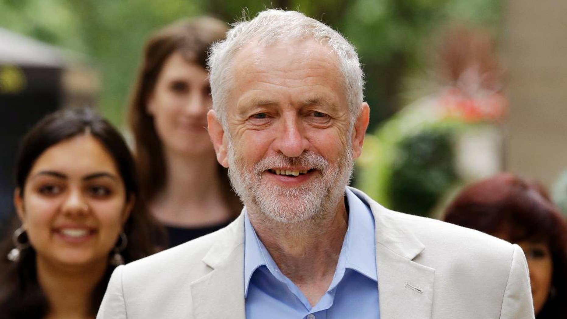 FILE - In this Thursday, July 21, 2016 file photo, British Labour Party leader Jeremy Corbyn walks with supporters as he arrives for a press conference to launch his bid to retain the leadership of the party in London. Britain's High Court on Thurday, July 28 has struck down an attempt to remove the lead of the country’s divided Labour opposition from a contest for the party leadership. Labour lawmakers are trying to unseat leader Jeremy Corbyn, a 67-year-old left-winger considered unelectable by the party's more centrist members. (AP Photo/Matt Dunham, file)