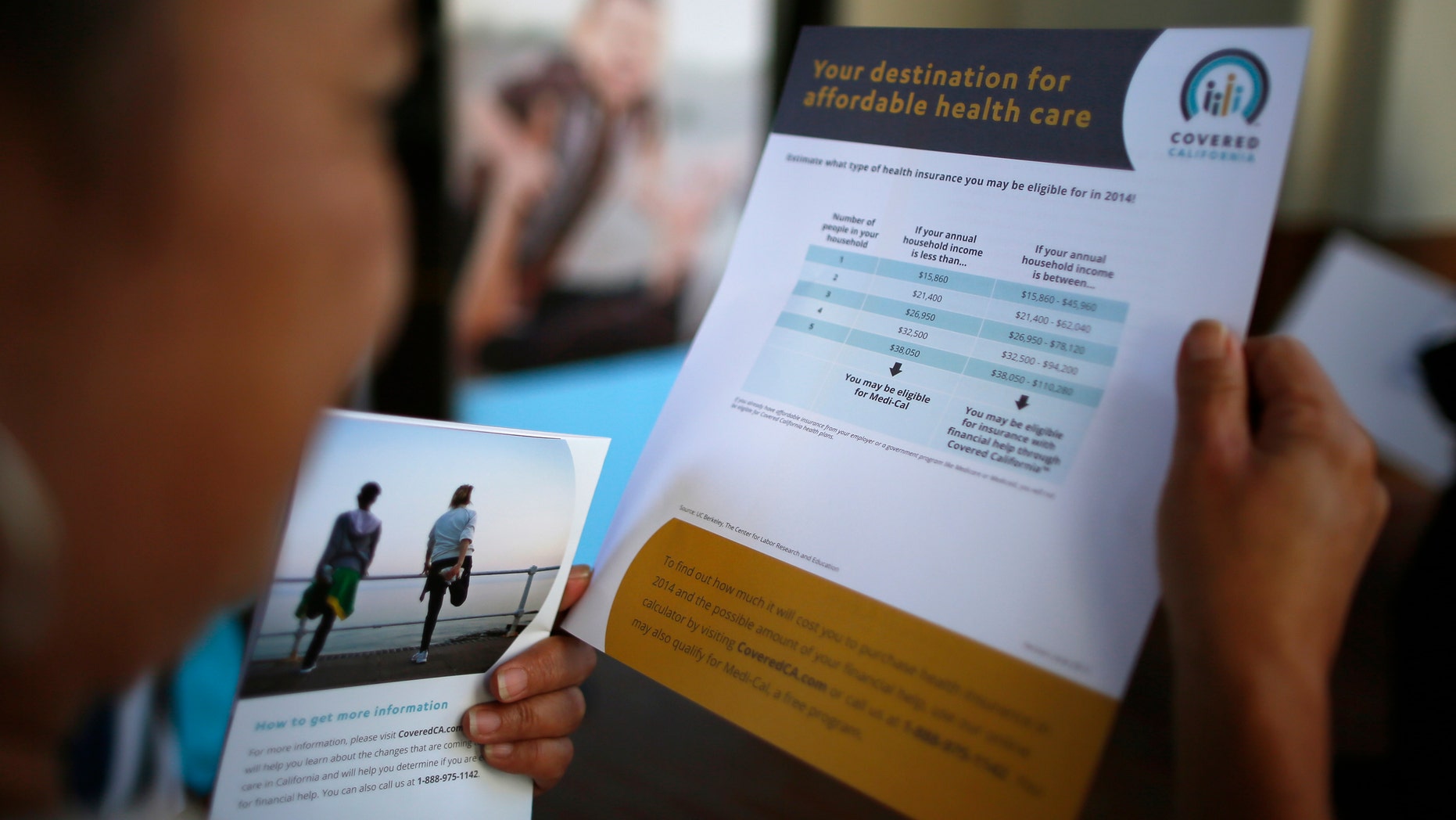 Kay Campos, 56, who has no health insurance and diabetes, browses leaflets at a Covered California event which marks the opening of the state's Affordable Healthcare Act.