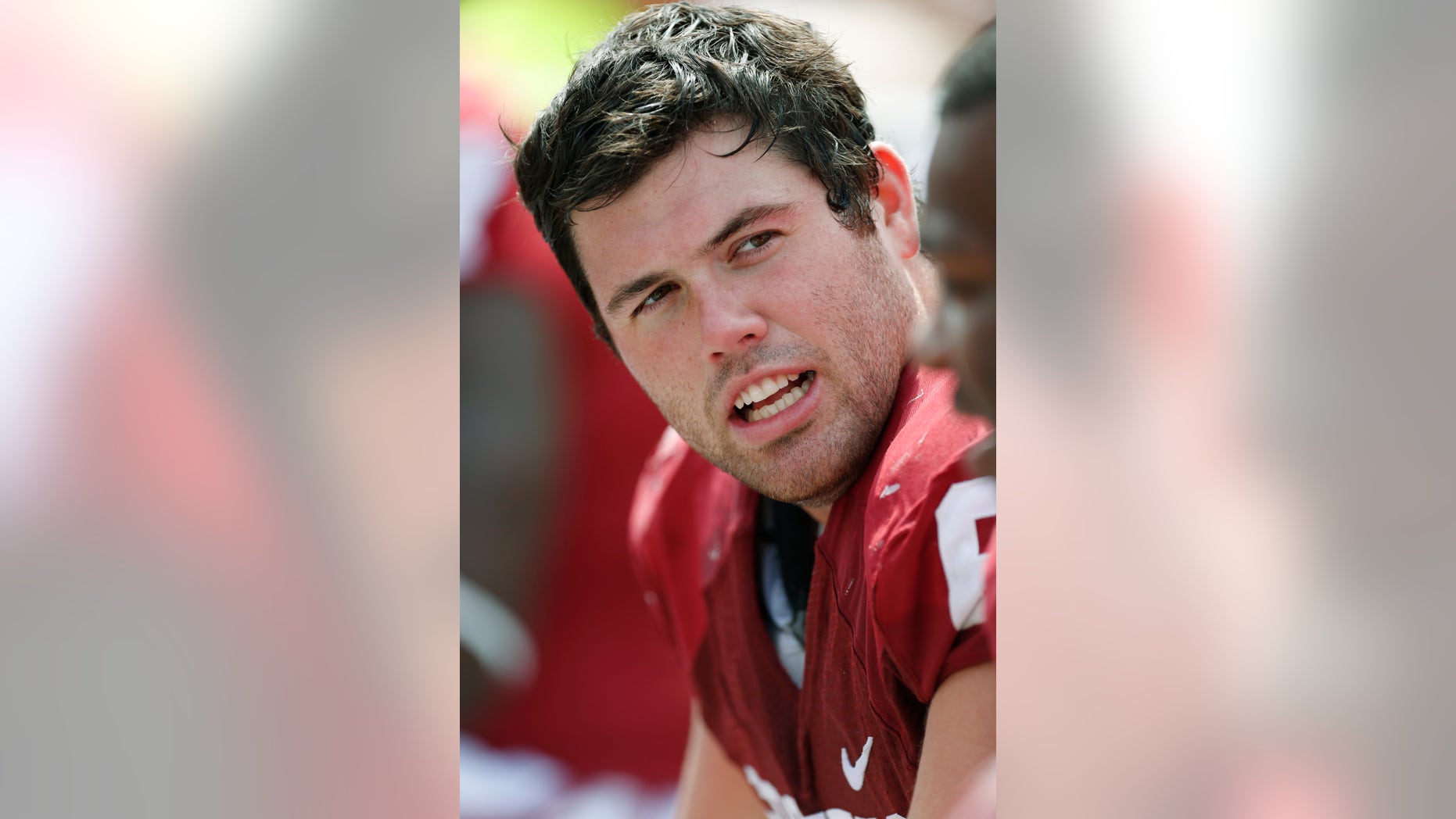 FILE - Oklahoma offensive lineman Gabe Ikard talks with a teammate on the bench in the fourth quarter of an NCAA college football game in this, Sept. 14, 2013 file photo. Gregarious and funny, Ikard has overcome his often-obscure position to become the face of the Sooners _ a spot usually reserved for a quarterback, running back or other star player. (AP Photo/Sue Ogrocki, File)