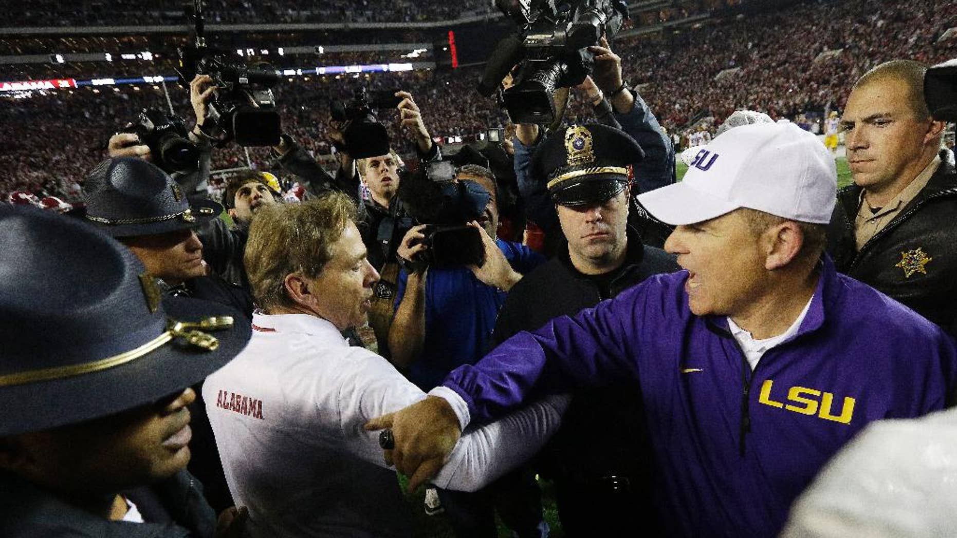 FILE - In this Nov. 9, 2013, file photo, Alabama head coach Nick Saban speaks with LSU head coach Les Miles after an NCAA college football game in Tuscaloosa, Ala. (AP Photo/Dave Martin, File)
