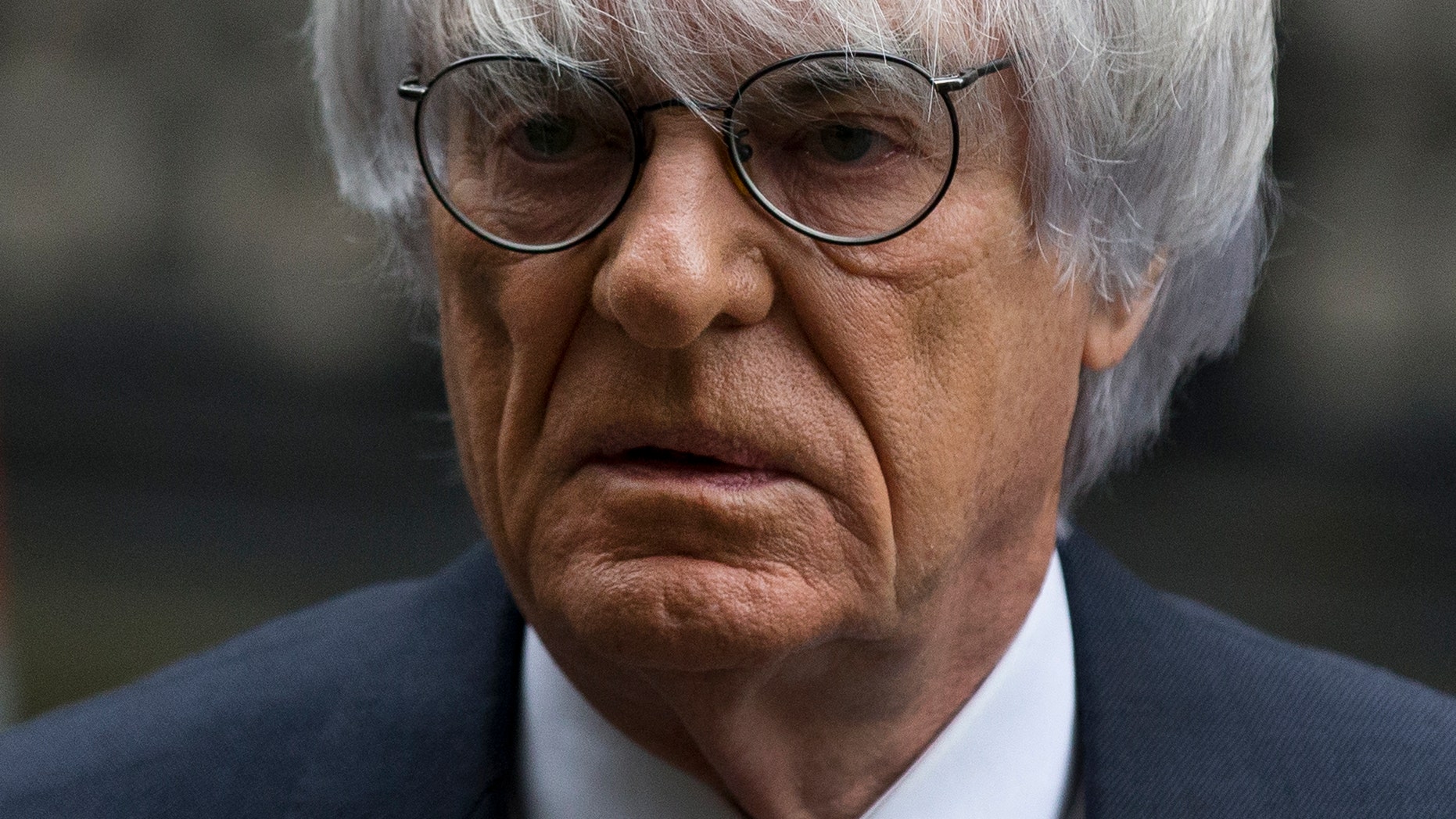 FILE - In this Nov. 11, 2013 file picture President and CEO of Formula One Management Bernie Ecclestone arrives for his case at the High Court in London. Formula 1 boss Bernie Ecclestone has won a multimillion-dollar case at London's High Court Thursday Feb. 20, 2014,relating to the sale of F1 in 2005 but the judge nevertheless said it was a corrupt deal. A former F1 shareholder, German media company Constantin Medien, had sued Ecclestone and other defendants for up to $144 million, claiming F1 was undervalued at the time of the sale to investment group CVC Capital Partners. (AP Photo/Matt Dunham. File)