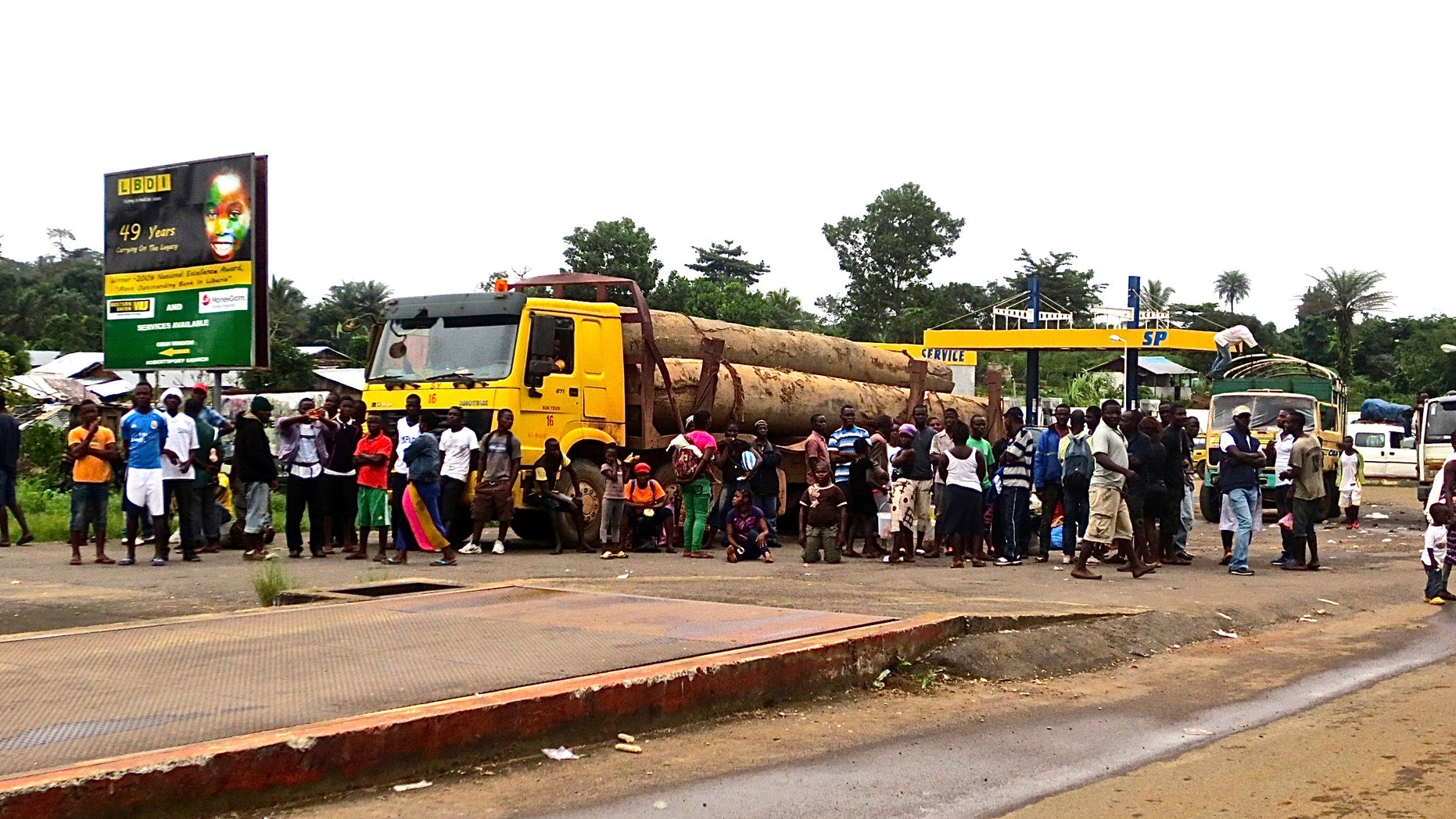A crowd gathers near a checkpoint, which controls the movement of people in and out of Ebola-hit regions, at the entrance to Bomi county in northwestern Liberia August 11, 2014. REUTERS