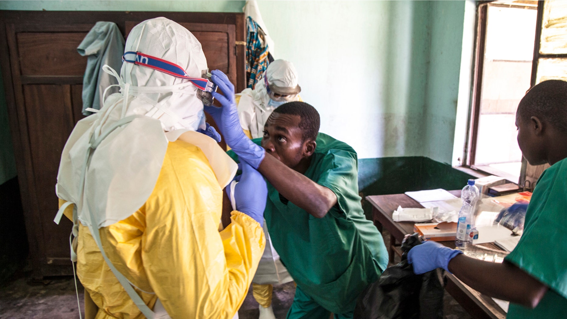 In this photo taken Saturday, May 12, 2018, health workers don protective clothing as they prepare to attend to patients in the isolation ward to diagnose and treat suspected Ebola patients, at Bikoro Hospital in Bikoro, the rural area where the Ebola outbreak was announced last week, in Congo.