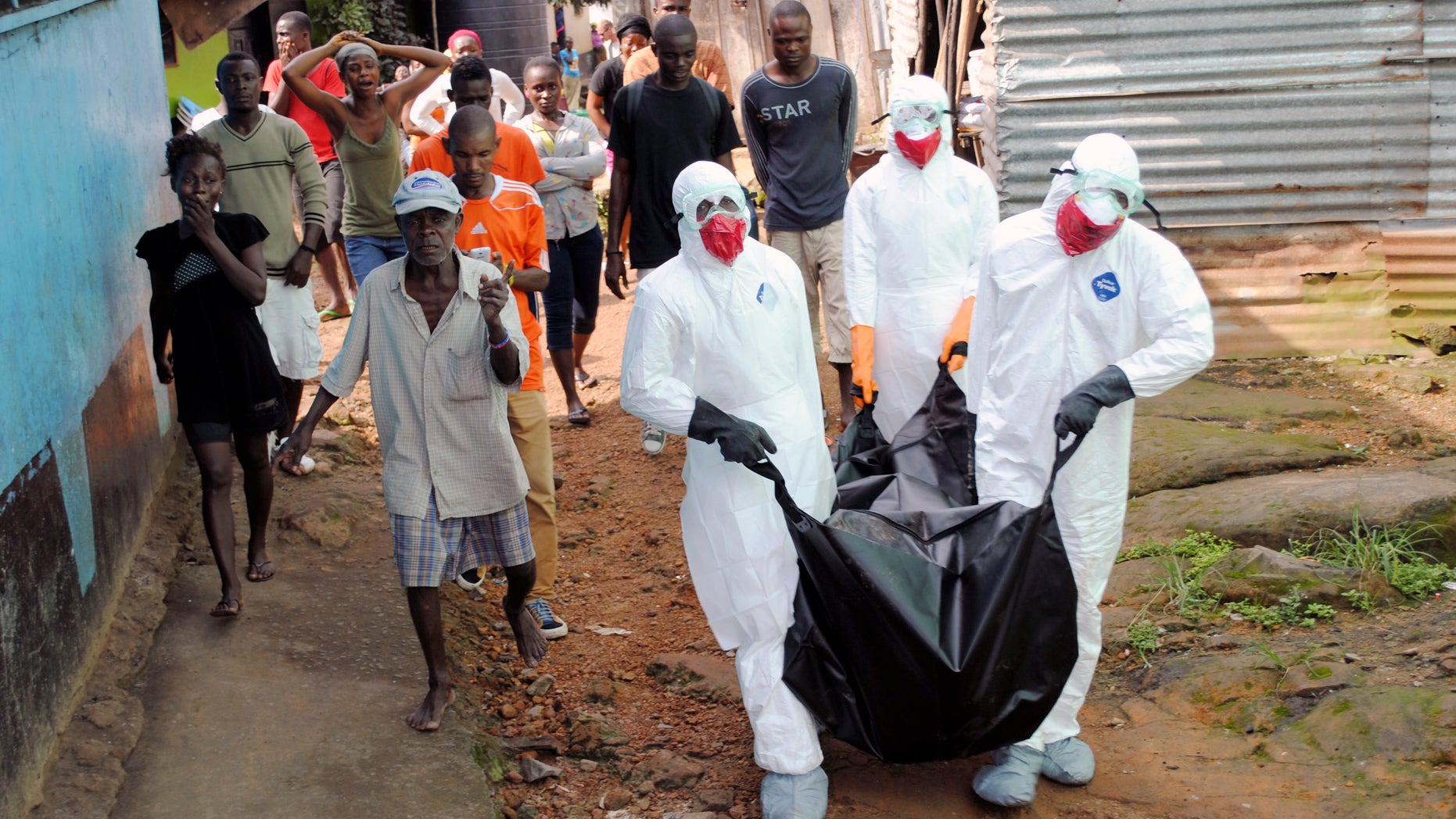 Health workers remove the body of Prince Nyentee, a 29-year-old man whom local residents said died of Ebola virus in Monrovia September 11, 2014. REUTERS/James Giahyue