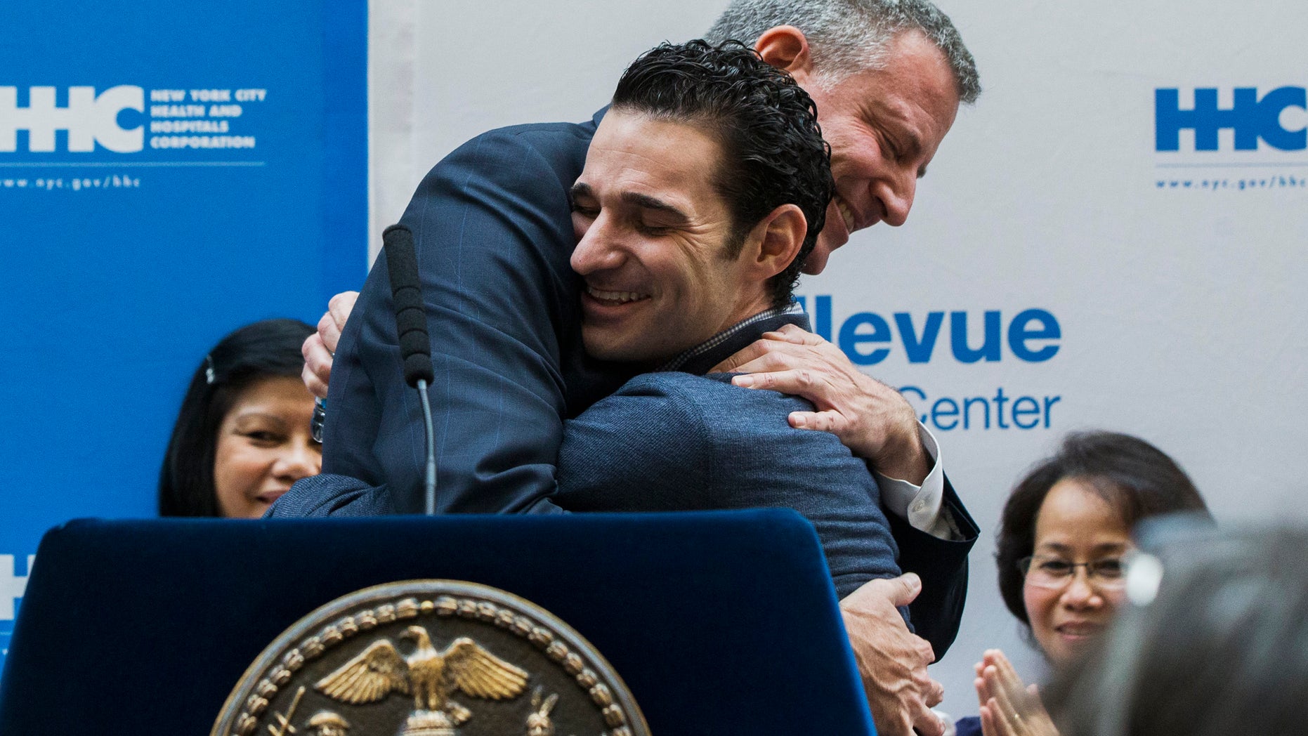 New York Mayor Bill de Blasio hugs Dr. Craig Spencer as he is discharged from Bellevue Hospital, after being stricken by Ebola, in New York November 11, 2014. REUTERS/Lucas Jackson