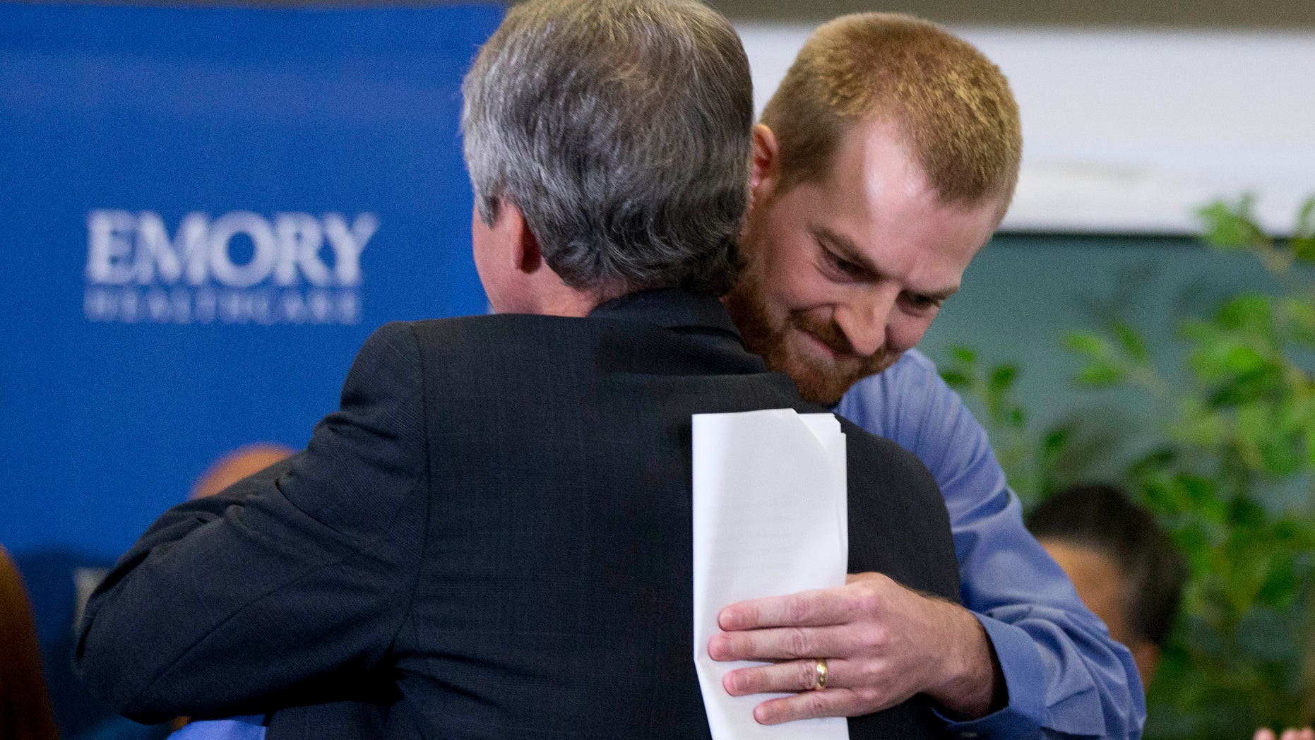 Ebola victim Dr. Kent Brantly, right, hugs a member of the medical staff that treated him, after being released from Emory University Hospital Thursday, Aug. 21, 2014, in Atlanta. (AP Photo/John Bazemore)