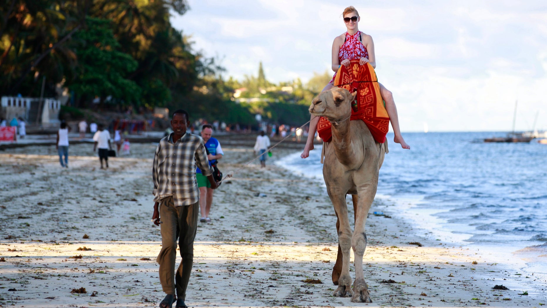 A tourist rides on a camel's back at the Jomo Kenyatta public beach in Kenya's coastal city of Mombasa, March 24, 2013. REUTERS/Joseph Okanga