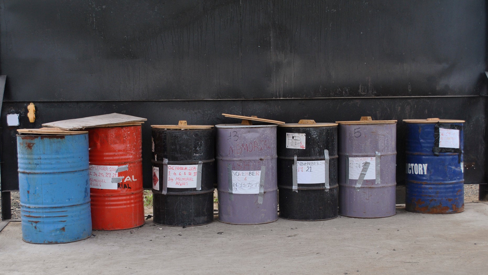 Barrels of cremated bodies of Ebola virus victims are seen in Boys Town, January 9, 2015. REUTERS/James Giahyue