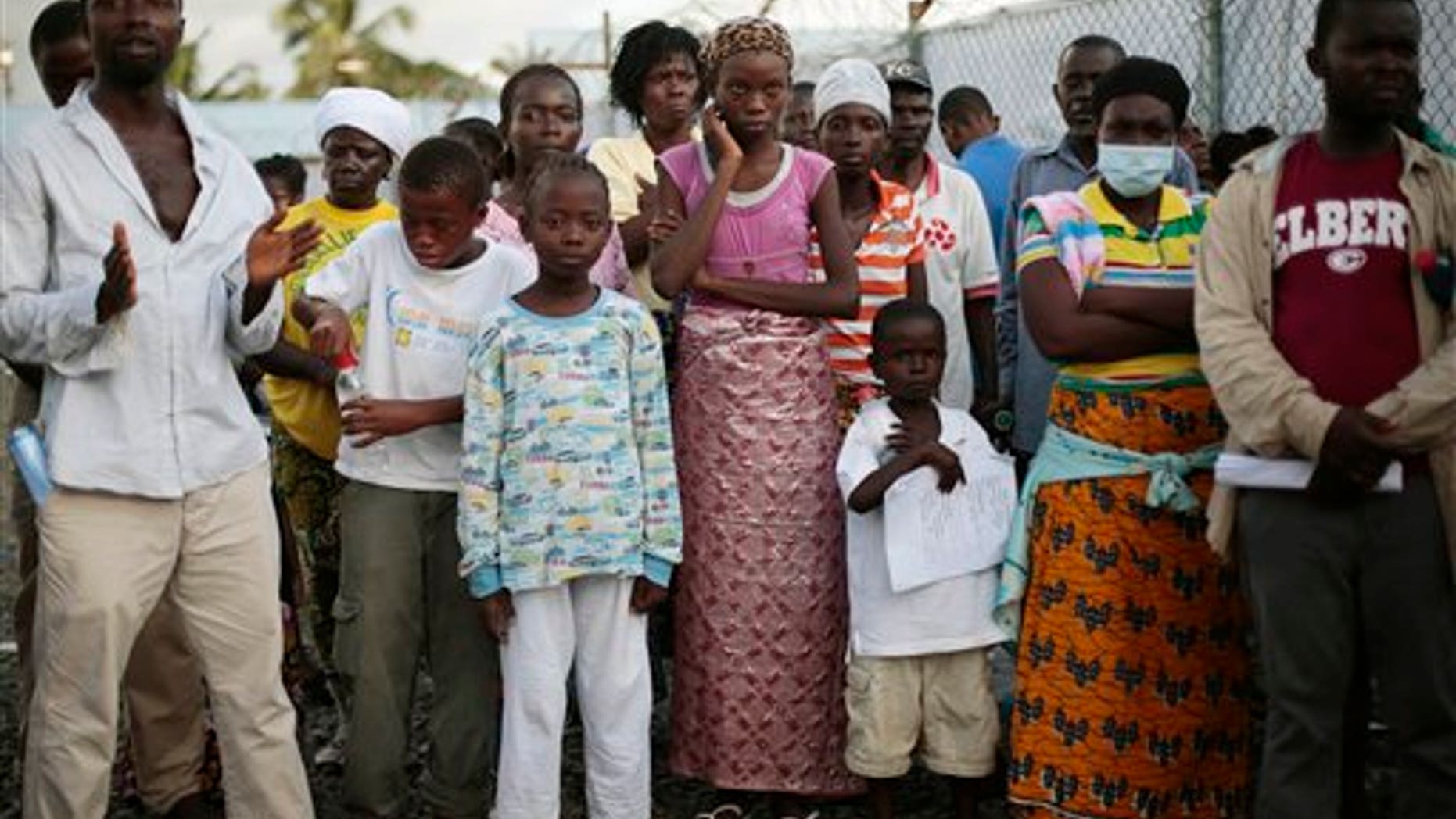 FILE - In this Tuesday, Sept. 30, 2014 file photo, patients being discharged from the Island Clinic Ebola treatment center in Monrovia, Liberia, wait to be sprayed with disinfectant. (AP Photo/Jerome Delay, File)