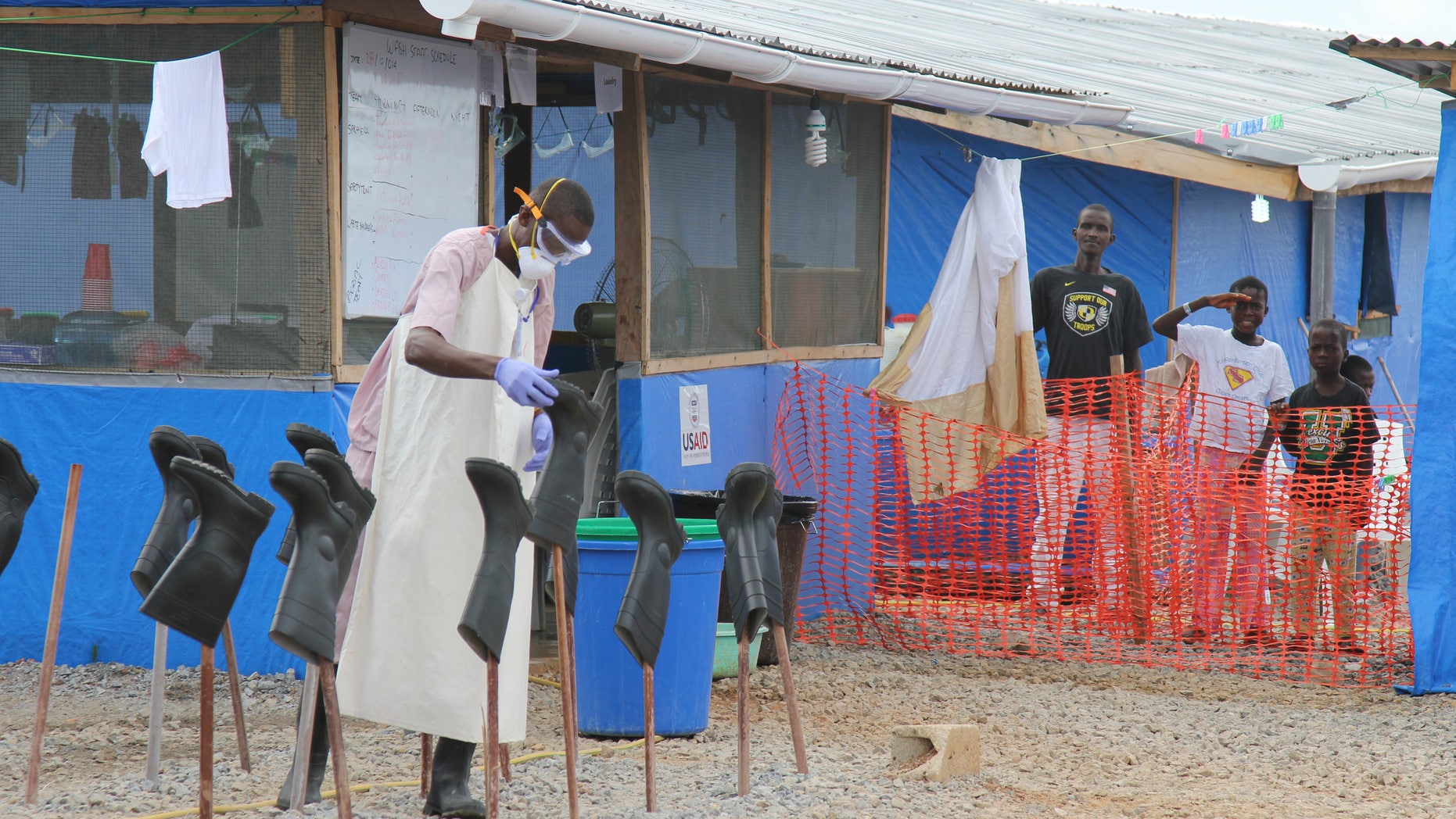 Boys Solomon (C, rear) and Joe (R, rear) stand in the "red zone" where they are being treated for Ebola at the Bong County Ebola Treatment Unit about 200 km (120 miles) east of the capital, Monrovia, October 28, 2014. REUTERS/Michelle Nichols