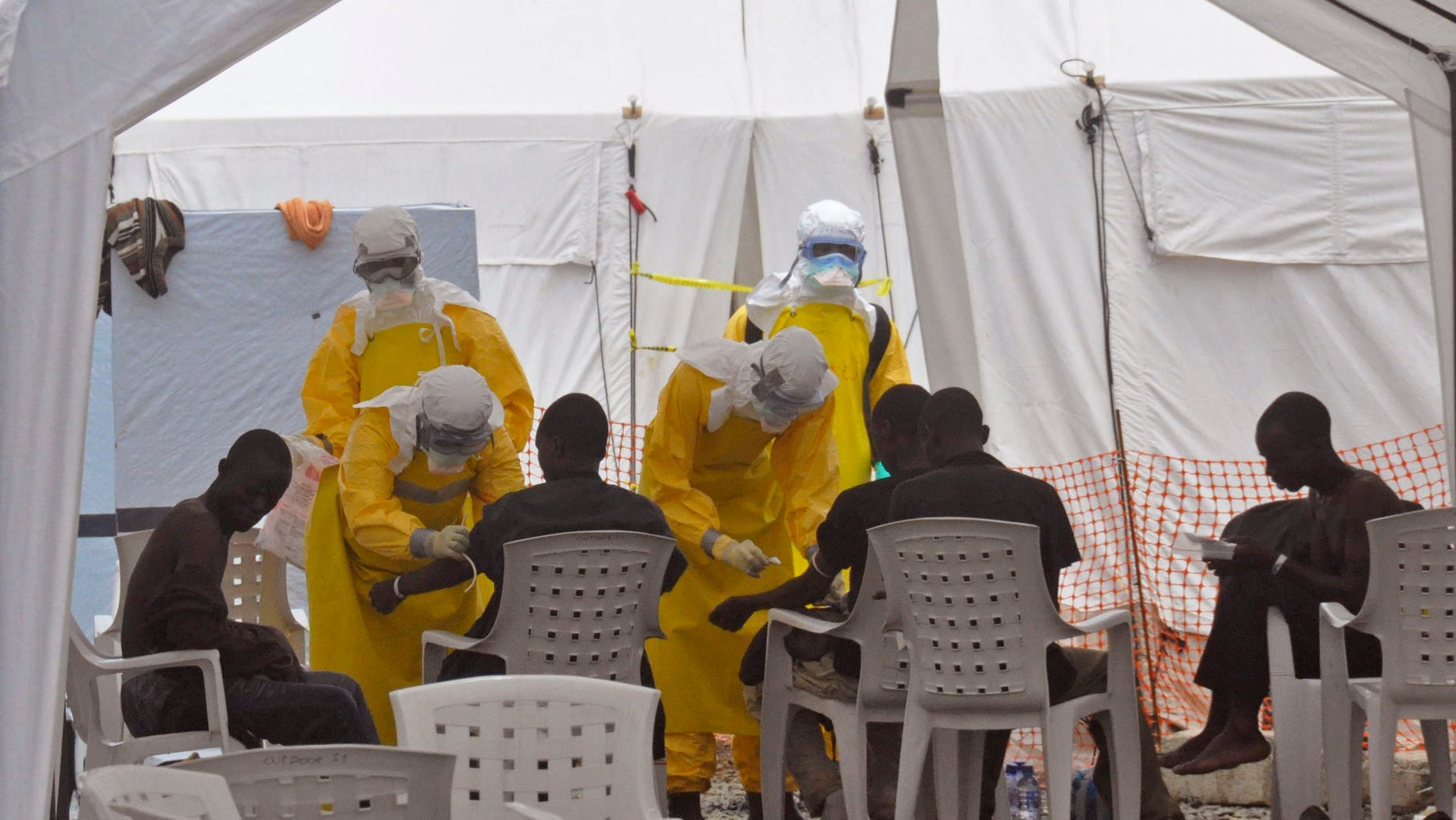 Health workers, attend to patients that contracted the Ebola virus, at a clinic in Monrovia, Liberia, Monday, Sept. 8, 2014. (AP Photo/Abbas Dulleh)