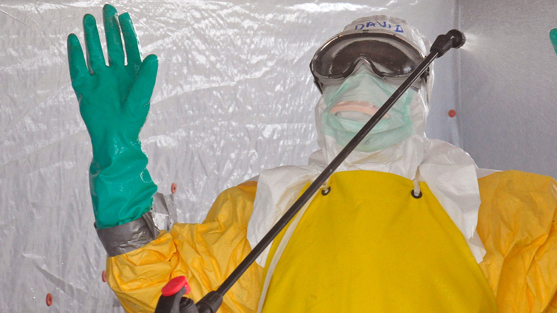 A health worker is sprayed with disinfectant after he worked with patients that contracted the Ebola virus, at a clinic in Monrovia, Liberia, Monday, Sept. 8, 2014. (AP Photo/Abbas Dulleh)