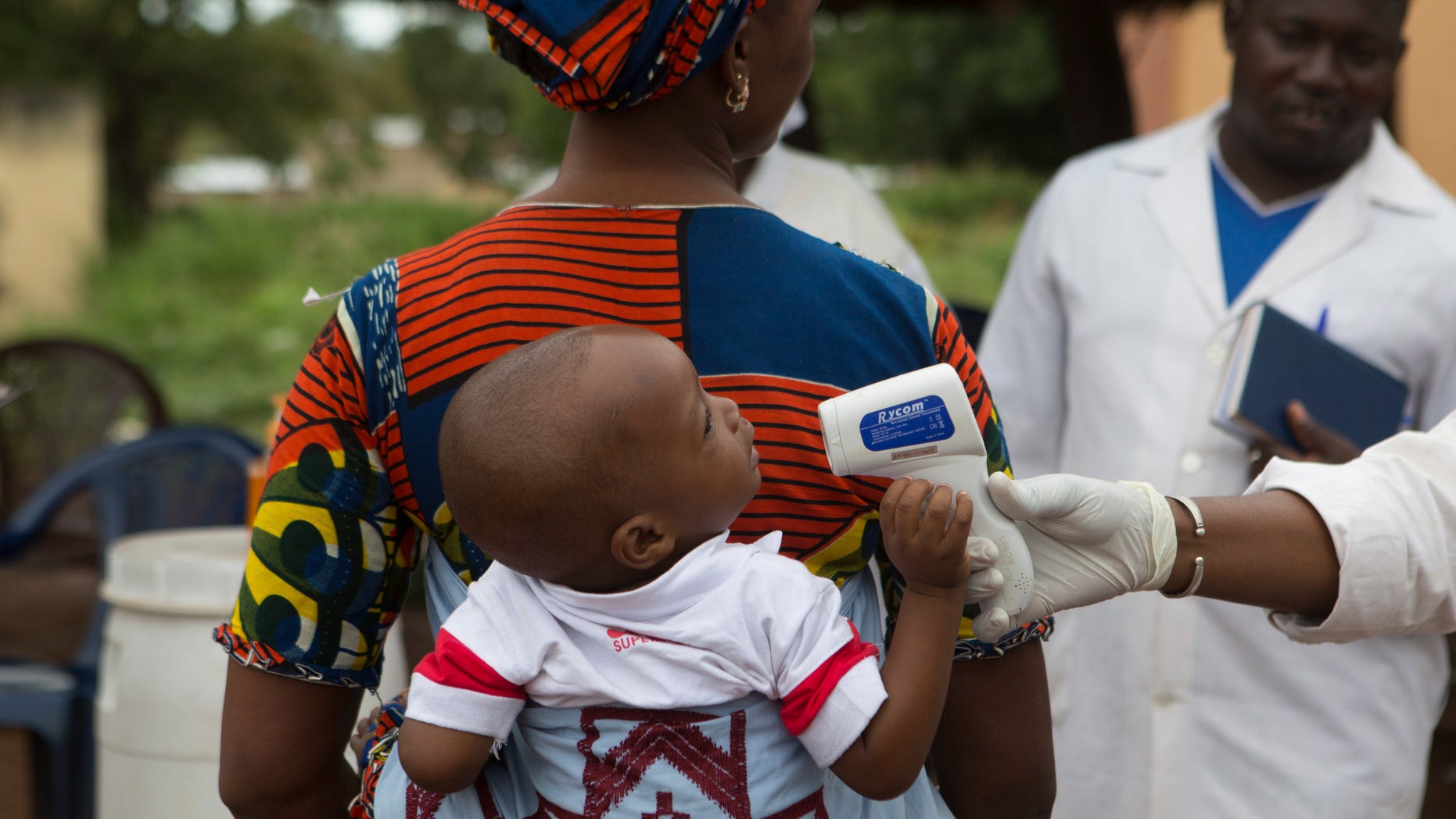 A health worker checks the temperature of a baby entering Mali from Guinea at the border in Kouremale, October 2, 2014. REUTERS/Joe Penney