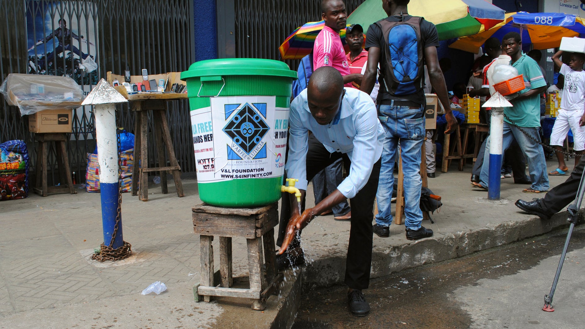 A man washes his hands as a preventive measure against the Ebola virus on a street in Monrovia, September 13, 2014. REUTERS/James Giahyue