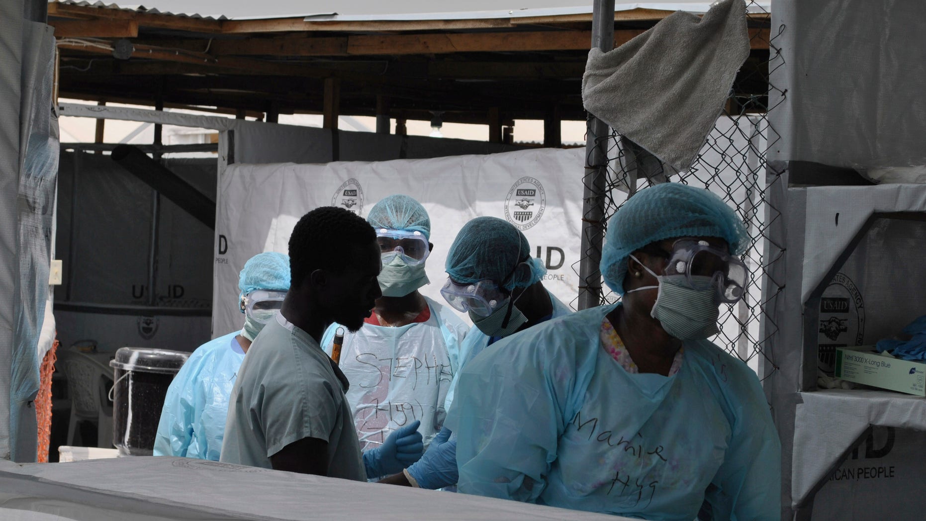 Health workers enter an Ebola treatment center in Monrovia, Liberia, December 16, 2014. REUTERS/James Giahyue