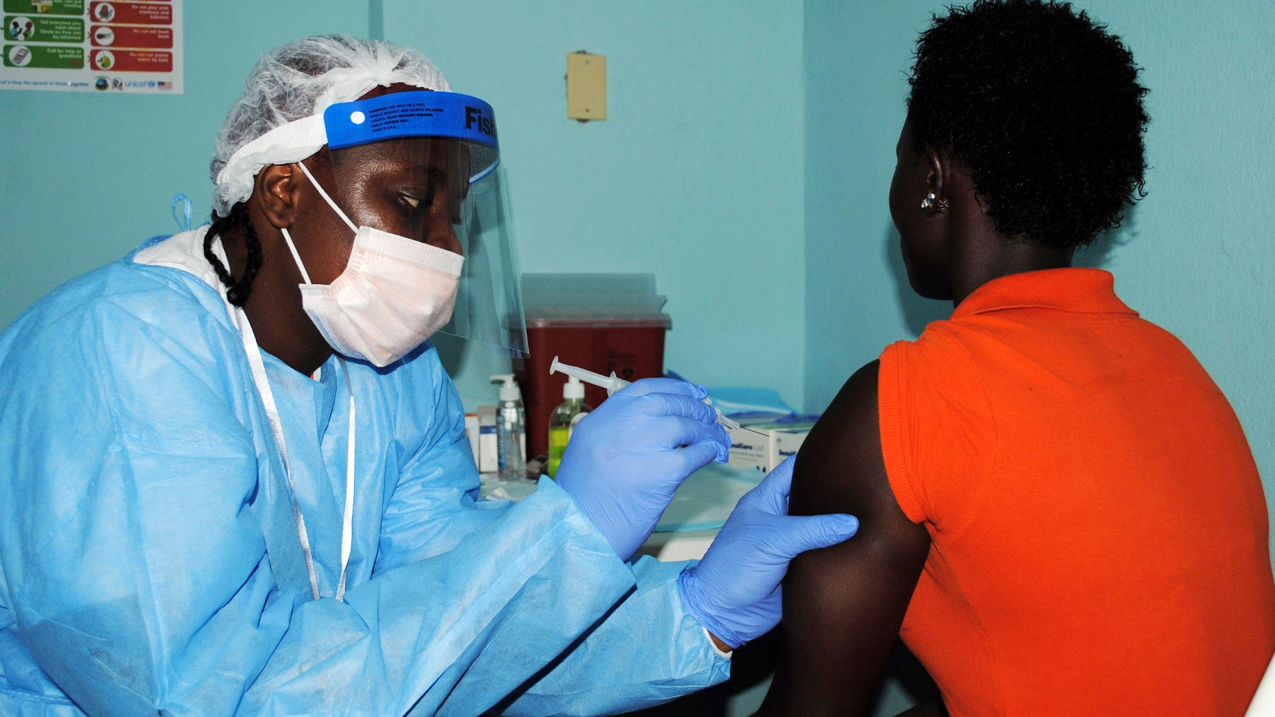 A health worker injects a woman with an Ebola vaccine during a trial in Monrovia, February 2, 2015. REUTERS/James Giahyue