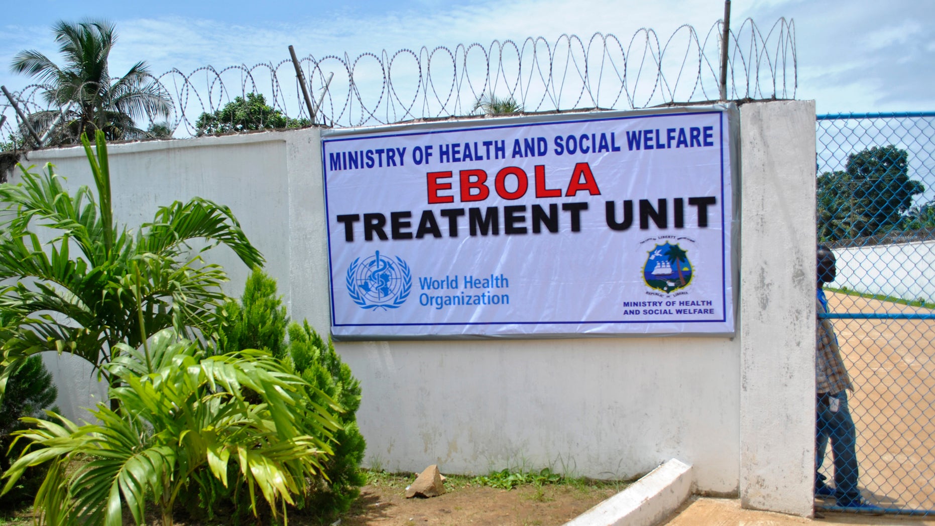 A man stands at the gate of an Ebola virus treatment center in Monrovia September 21, 2014. REUTERS/James Giahyue