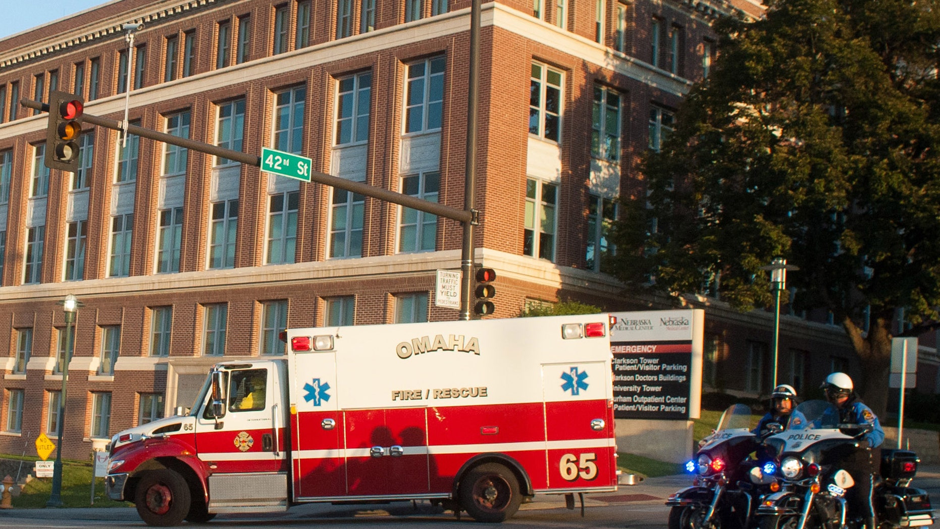 An ambulance transports Ashoka Mukpo, who contracted Ebola while working in Liberia, to the Nebraska Medical Center's specialized isolation unit Monday, Oct. 6, 2014, in Omaha, Neb., where he will be treated for the deadly disease. (AP Photo/Dave Weaver)