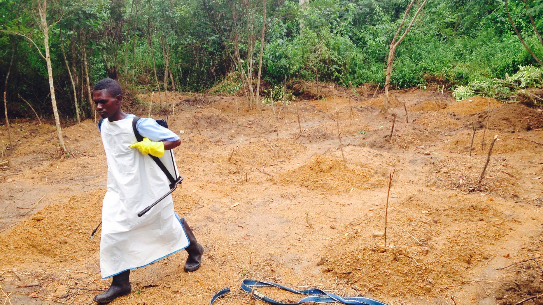 A volunteer walks at a cemetery near the Mediciens Sans Frontieres treatment centre in Kailahun July 18, 2014.