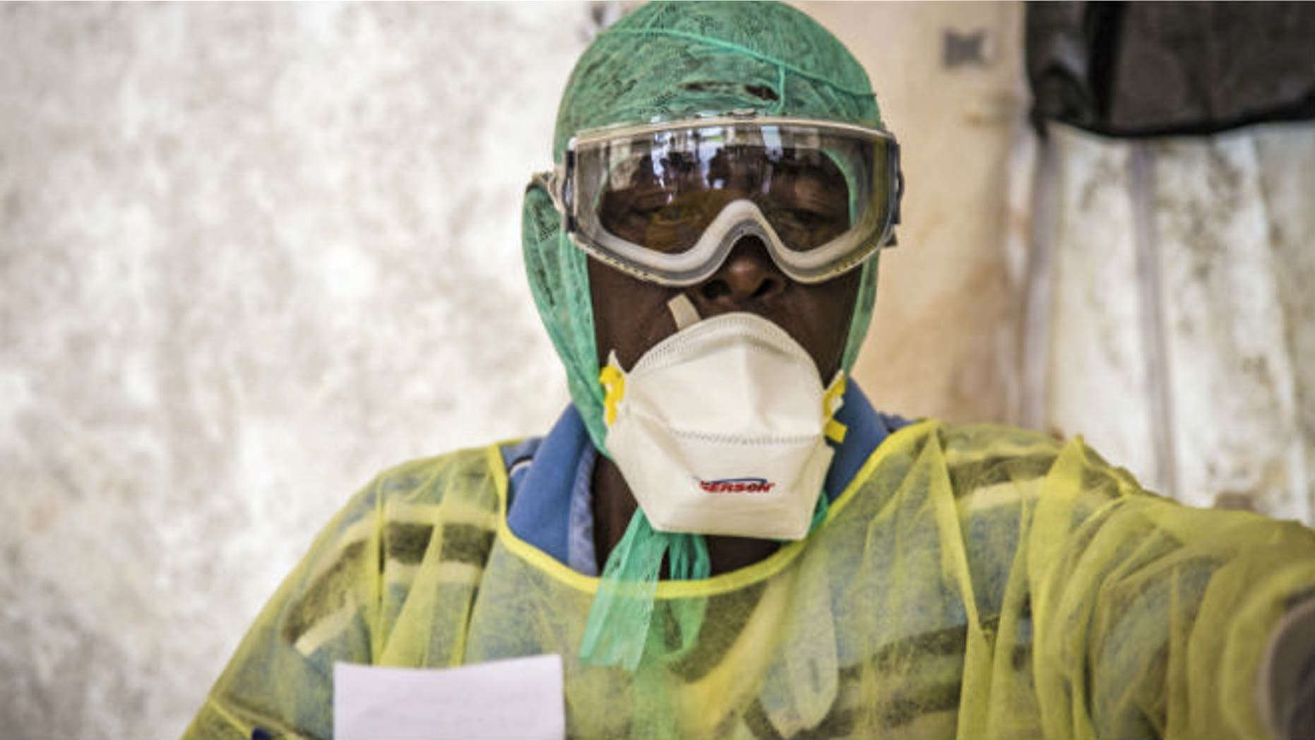 In this photo taken Monday, Aug. 11, 2014, a health worker examines patients for Ebola inside a screening tent, at the Kenema Government Hospital around186 miles from the capital city of Freetown in Kenema, Sierra Leone. (AP Photo/ Michael Duff)