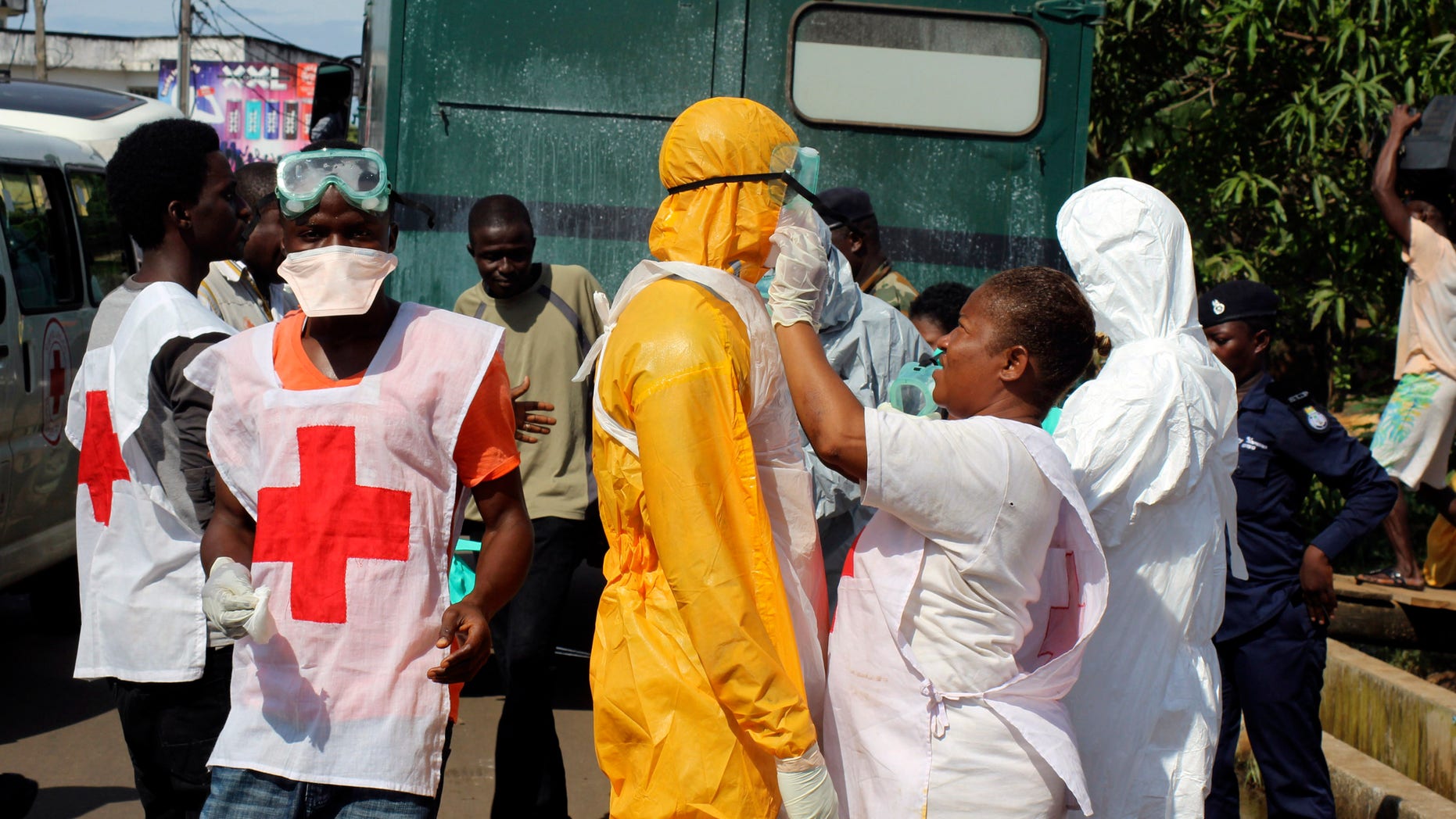 A health worker fixes another health worker's protective suit in the Aberdeen district of Freetown, Sierra Leone, October 14, 2014. REUTERS/Josephus Olu-Mammah