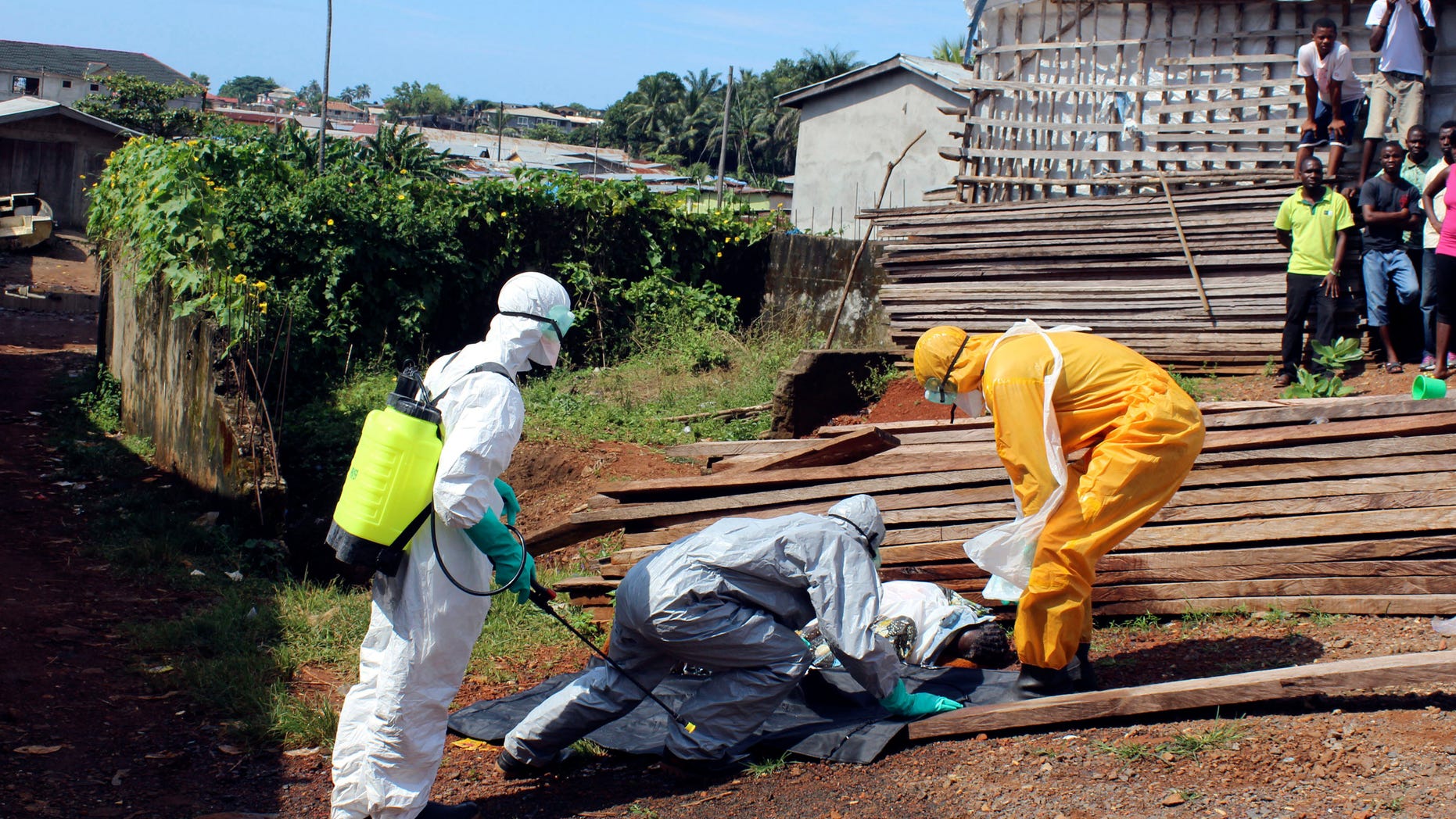 Health workers remove the body a woman who died from the Ebola virus in the Aberdeen district of Freetown, Sierra Leone, October 14, 2014. REUTERS/Josephus Olu-Mammah