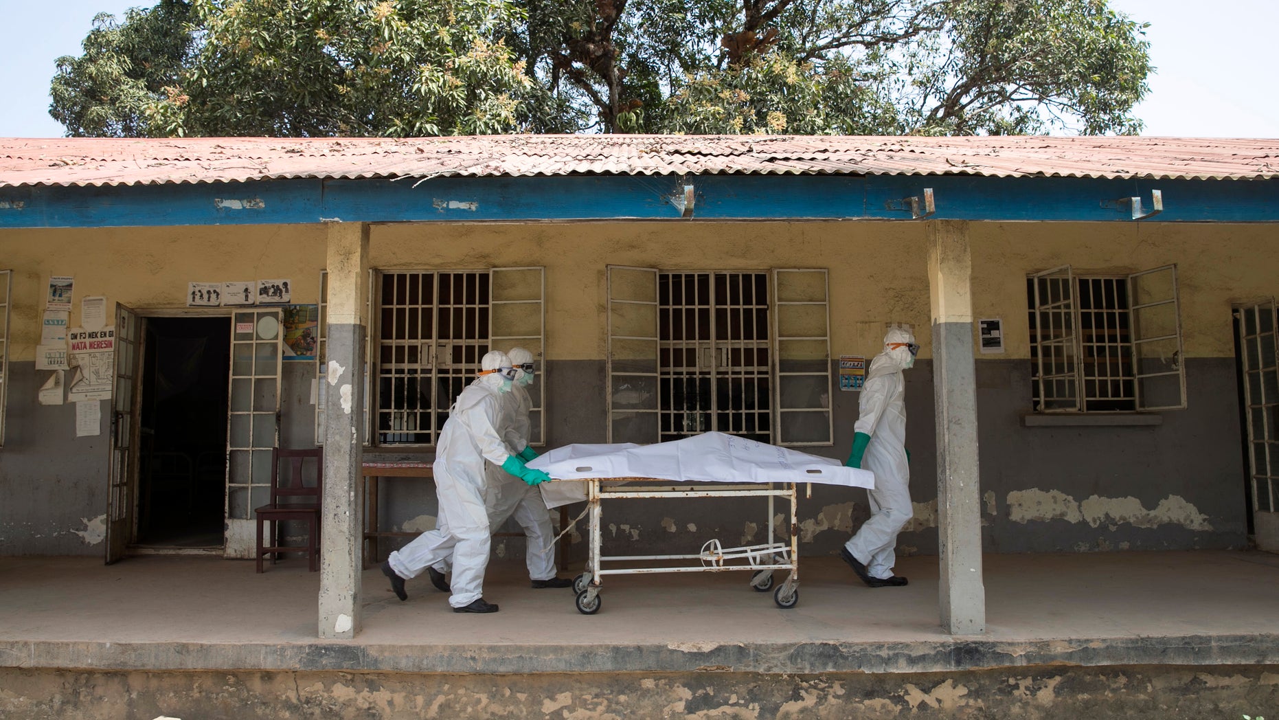 Health workers push a gurney with a dead body at a Red Cross facility in the town of Koidu, Kono district in Eastern Sierra Leone December 19, 2014. REUTERS/Baz Ratner