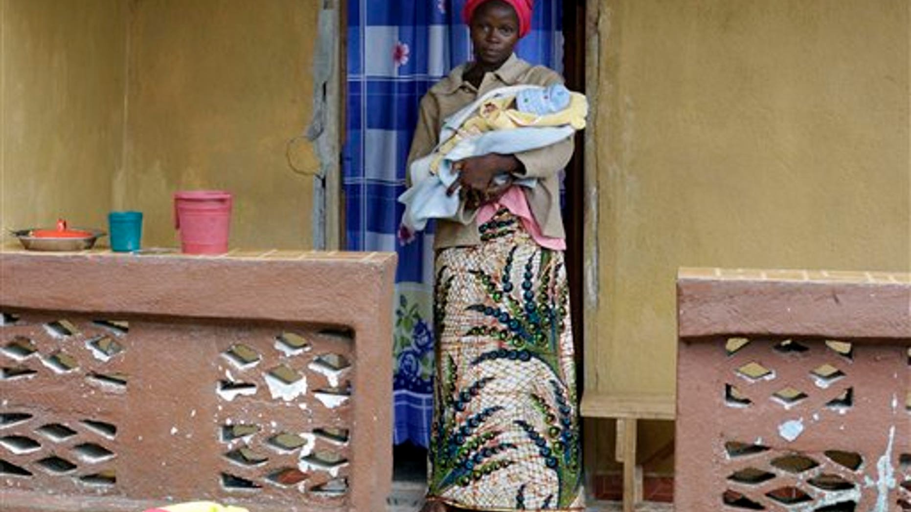 In this Sunday, Aug. 16, 2015 file photo, Ebola survivor Victoria Yillia stands with her newborn son Barnabas outside her home in Kenema, on the outskirts of Freetown, Sierra Leone. (AP Photo/Sunday Alamba file)