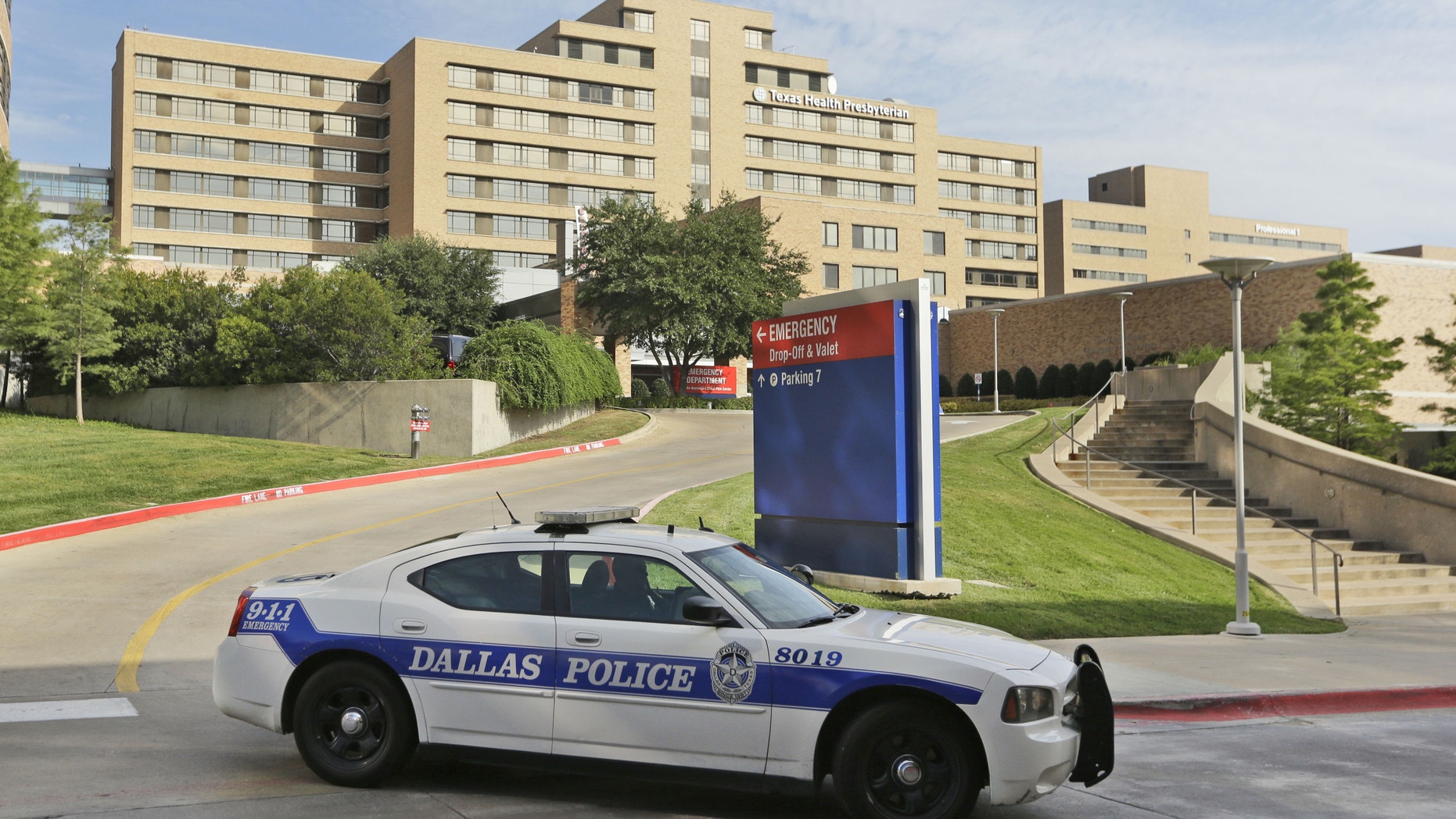 A police car drives past the entrance to the Texas Health Presbyterian Hospital in Dallas, Tuesday, Sept. 30, 2014. (AP Photo/LM Otero)