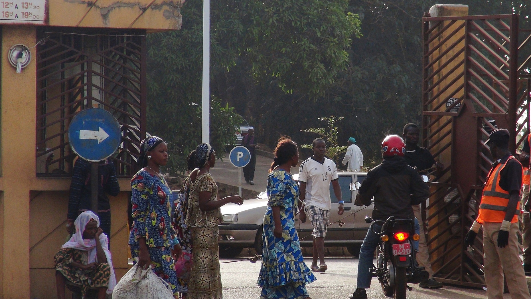 People walk in front of the entrance of the Donka Hospital, where victims of the ebola disease are being treated, in Guinea. (REUTERS/Saliou Samb)