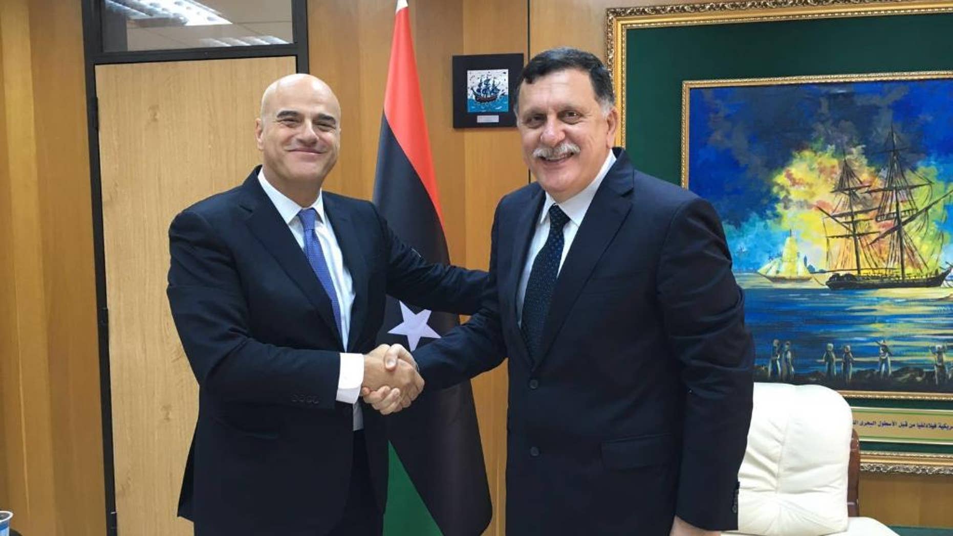 Italian oil giant Eni CEO Claudio Descalzi, left, and and Libya’s new prime minister, Fayez al-Serraj shake hands in Tripoli, Libya, Saturday, June 4, 2016. The CEO of Italian oil giant Eni has traveled to Tripoli for the first time since July 2014 to meet with the new head of Libya’s U.N.-backed government. Eni said in a statement that the meeting Saturday underlined Eni’s commitment to continuing operations in Libya and to support the National Oil Corporation’s efforts to increase production. (ENI via AP)