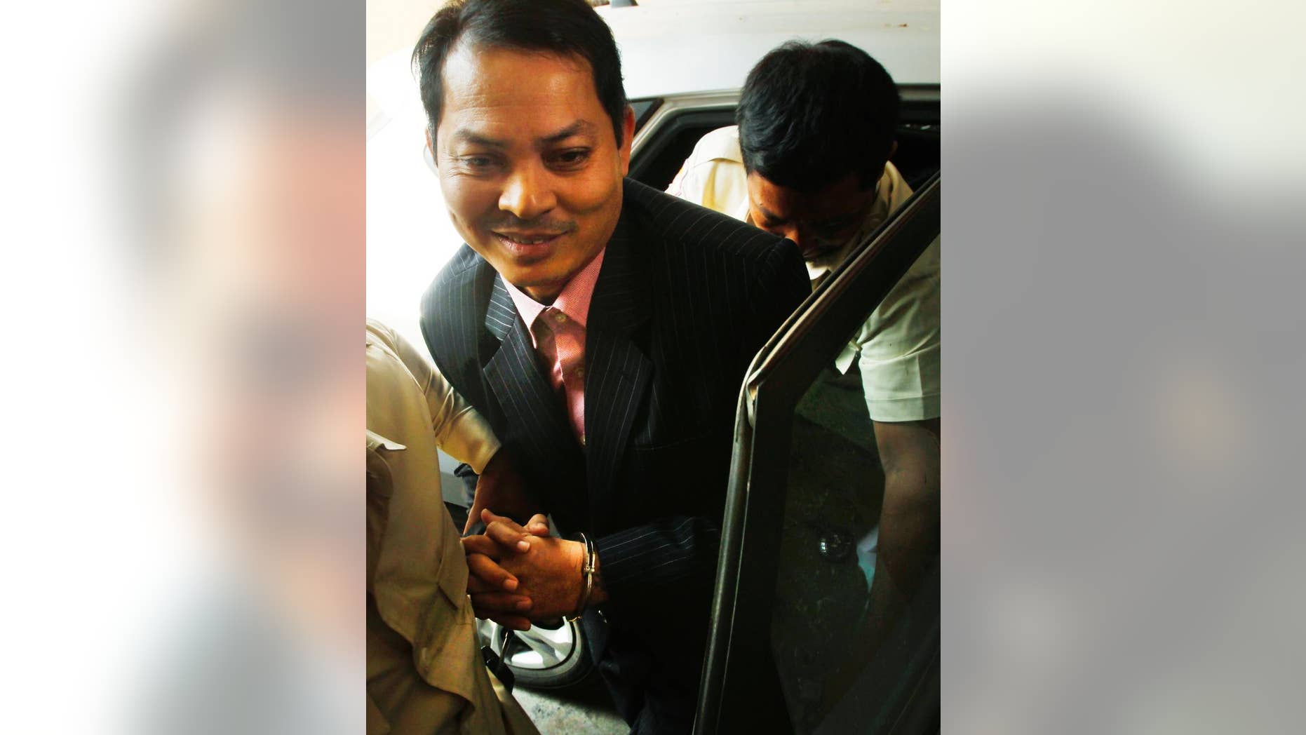 Suth Dina, former Cambodian Ambassador to South Korea, smiles upon his arrival at Phnom Penh Municipal Court, in Phnom Penh, Cambodia, Thursday, April 7, 2016. Cambodia’s court formally charged the country’s envoy to South Korea of embezzlement and abusing of power that could facing up to 15 years in prison. (AP Photo/Heng Sinith)