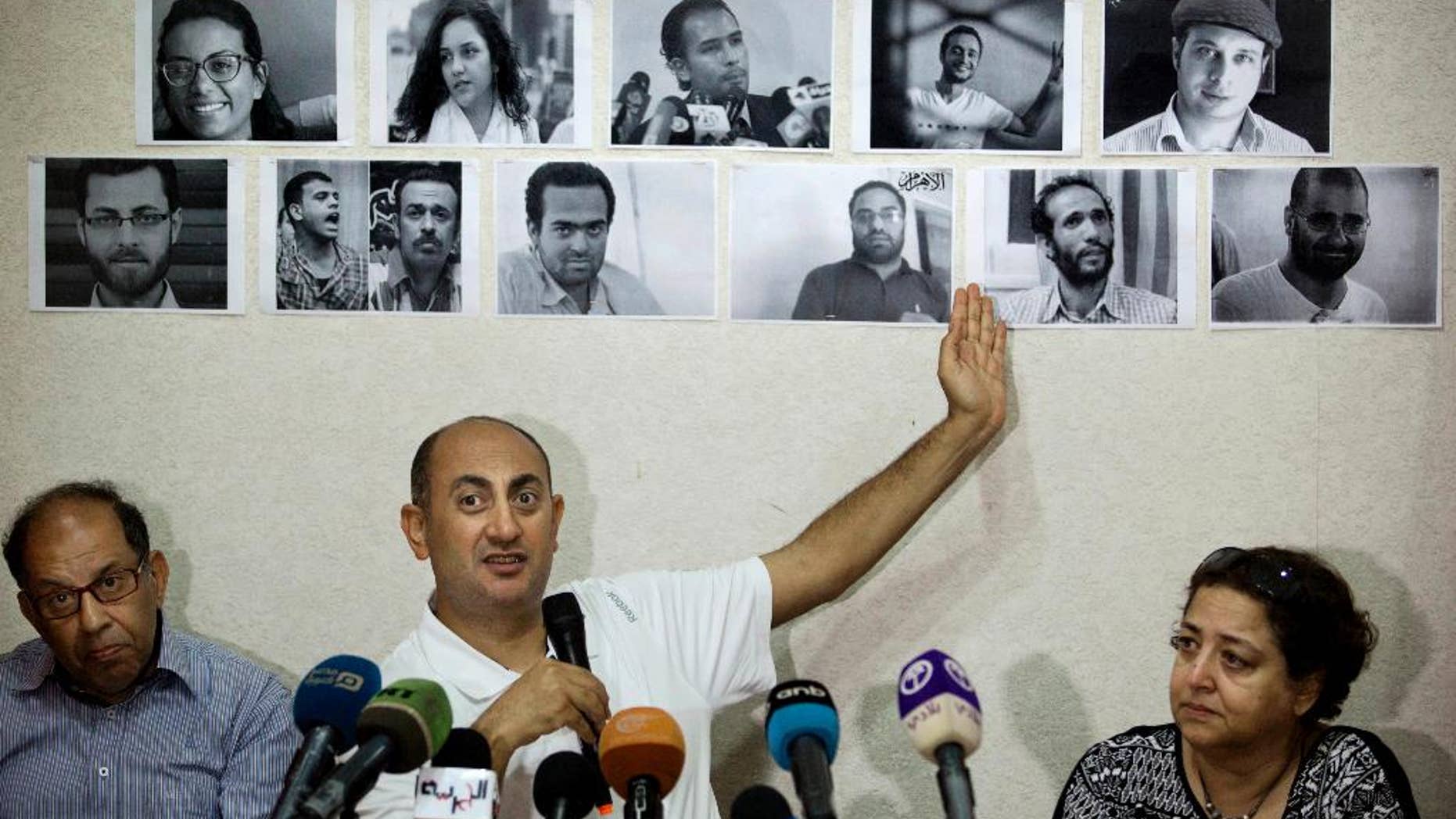 FILE - In this June 22, 2016 file photo, Egyptian lawyer and former presidential candidate Khaled Ali points to photos of jailed activists, who were arrested during protests over two disputed Red Sea islands, including Egyptian rights lawyer Malek Adly, top row third right, during a press conference, in Cairo, Egypt. An Egyptian court has ordered the release of a rights lawyer who had been held without charge in solitary confinement for over 100 days for allegedly defying President Abdel-Fattah el-Sissi. The Saturday, Aug. 27, 2016, ruling in favor of Malek Adly, who was incarcerated on a rolling series of administrative detention orders, rejected an appeal by prosecutors after a court ordered Adly's release on Thursday. (AP Photo/Amr Nabil, File)