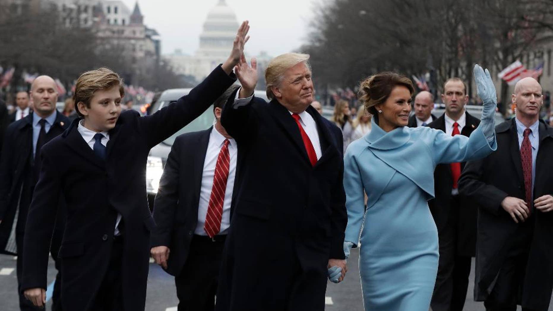 FILE - In this Jan. 20, 2017, file photo, President Donald Trump waves as he walks with first lady Melania Trump and their son Barron during the inauguration parade on Pennsylvania Avenue in Washington. Think it’s tough to be a kid? Try being a “first kid” - the child of an American president. (AP Photo/Evan Vucci, File)