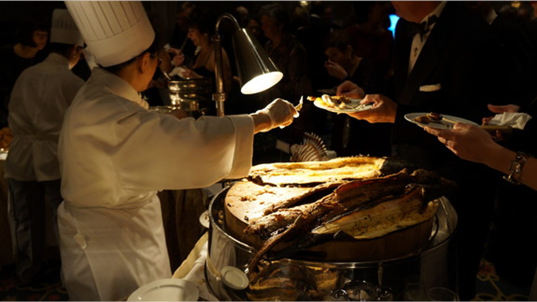 The adventurous hors d'oeuvres have become a staple of the glitzy gala, where astronauts and archaeologists rub shoulders with oceanographers and nature photographers. Shown here, a chef serves snakehead fish.