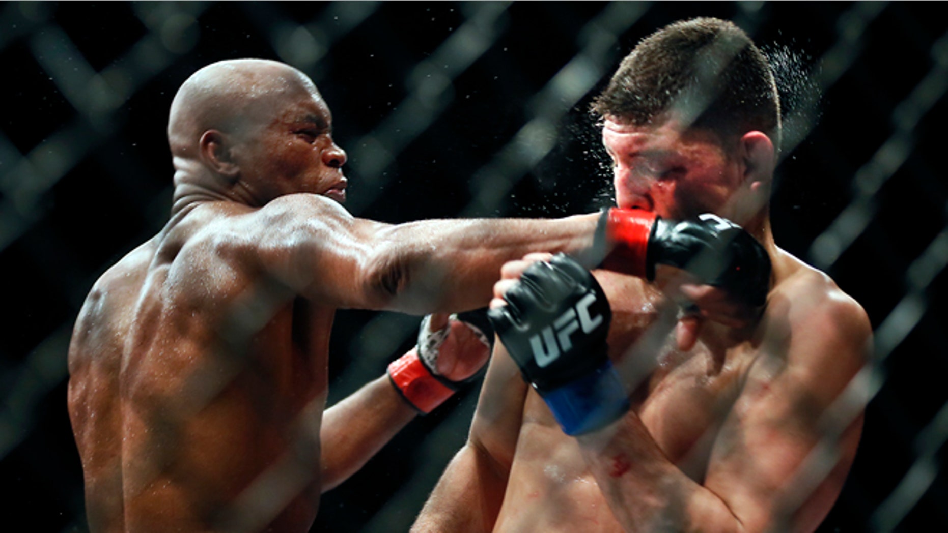 Middleweight Anderson Silva draws a fist across the face of Nick Diaz during their fight at the MGM Grand Garden Arena in Las Vegas on Saturday, Jan. 31, 2015. (AP Photo/Las Vegas Sun/LE Baskow)