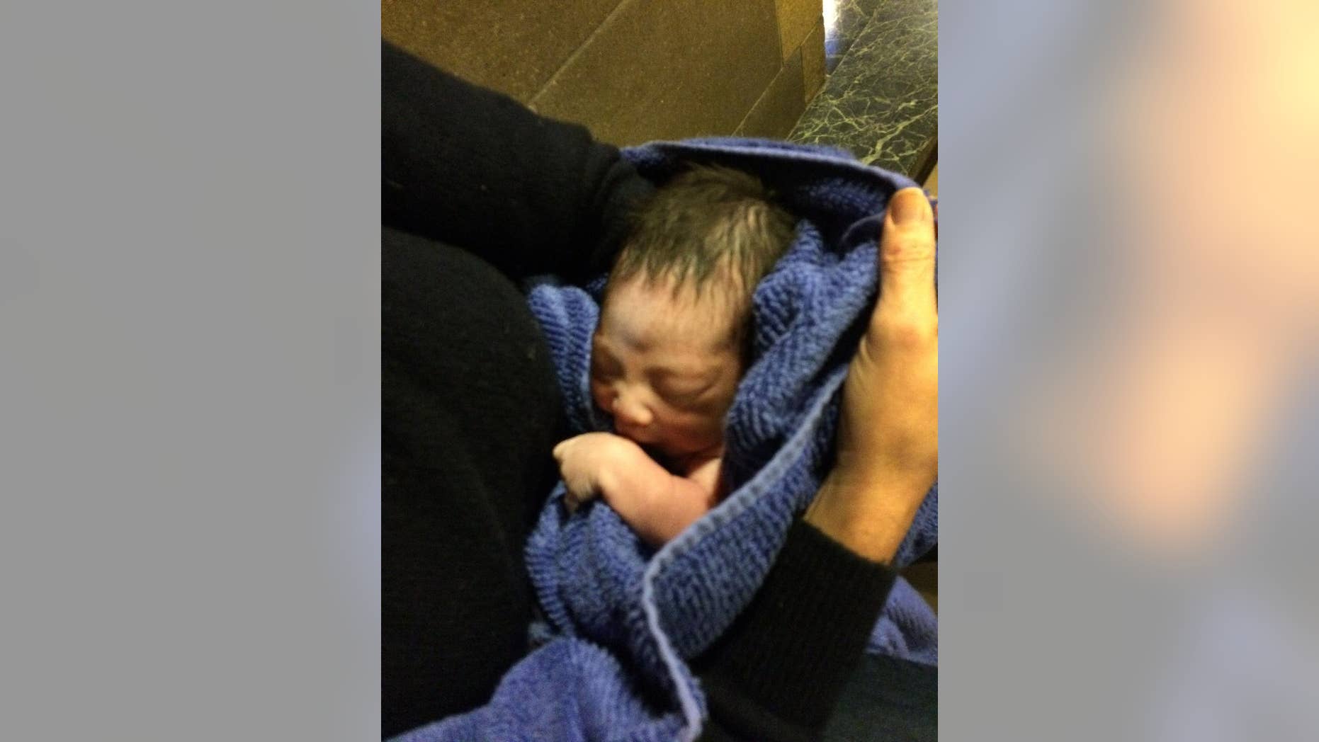 In this Monday, Nov. 23, 2015 photo provided by Paul Cerni, an unidentified woman holds a baby at the Holy Child of Jesus Church in the Richmond Hill section of Queens, New York. A church custodian found the abandoned newborn Monday in the church nativity scene. New York has a so-called safe haven law that says a newborn can be dropped off anonymously at a church, hospital, police or fire station without fear of prosecution. But the law, known as the Abandoned Infant Protection Act, requires that the child be left with someone or for authorities to be called immediately. Police are searching for the mother. (Paul Cerni via AP)