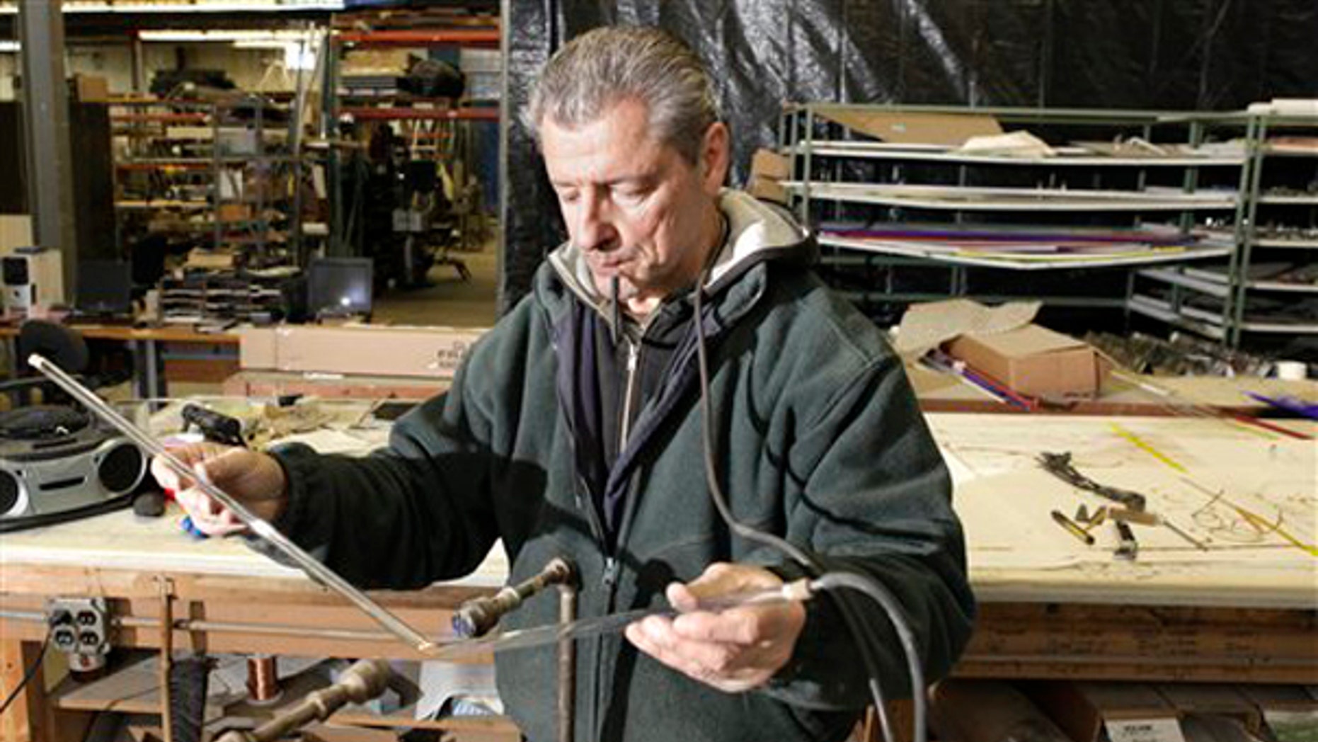 In this photo made Jan. 13, 2010, Rick Westover bends neon tubing for a sign at Glavin Industries in Solon, Ohio. (AP)